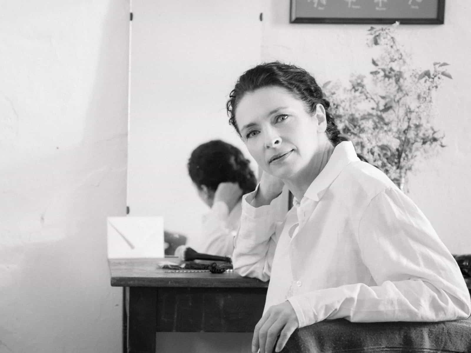 Braut schminkt sich mit Handspiegel in rustikalem Zimmer