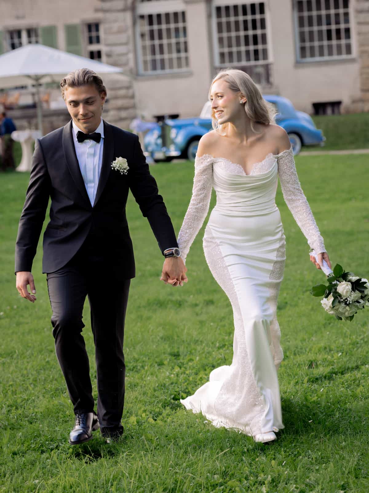 Brautpaar geht Hand in Hand durch Schlosspark Kartzow bei Sommerhochzeit