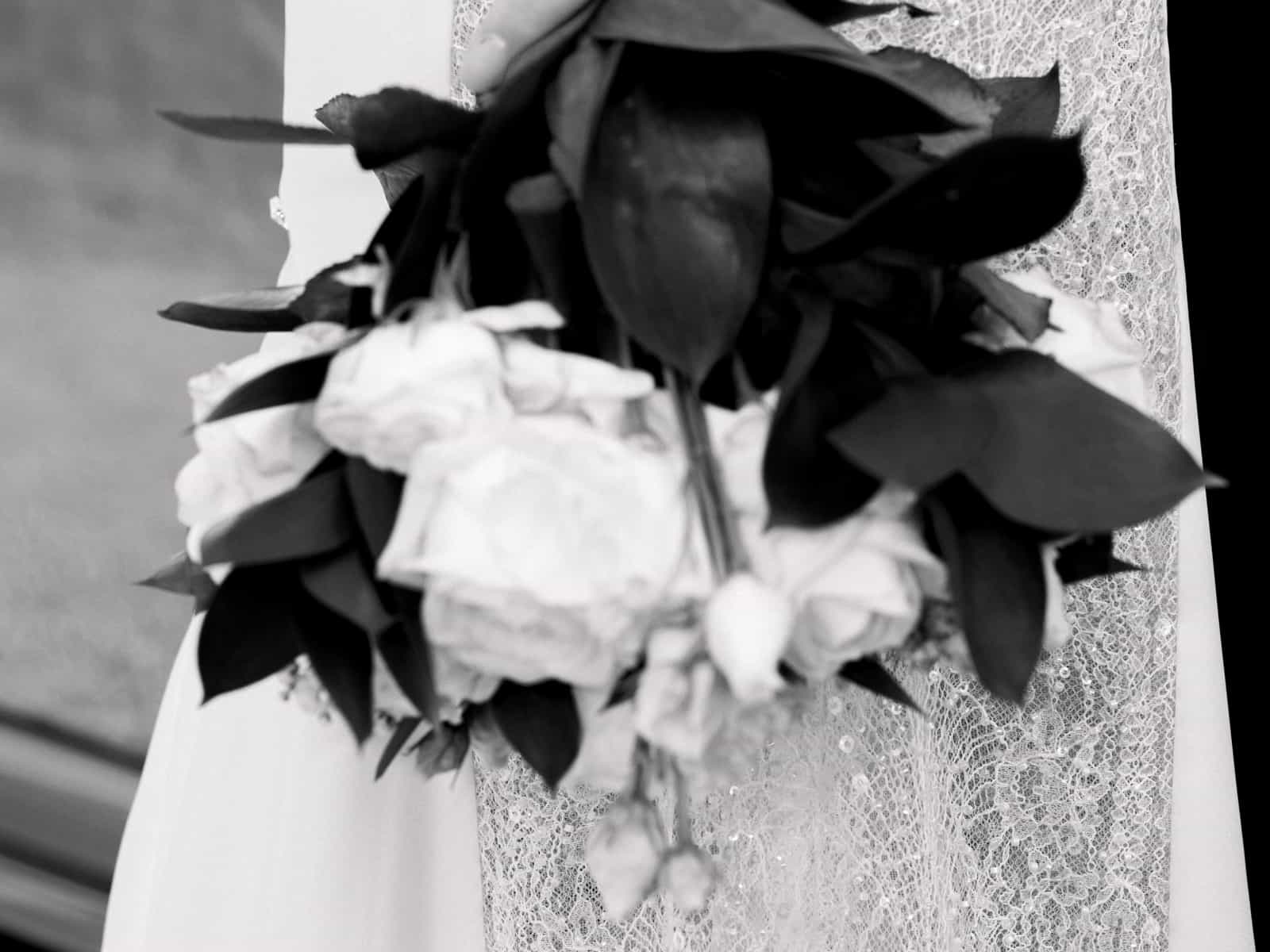 Nahaufnahme Brautstrauß mit weißen Rosen und Spitzenkleid bei Schloss Kartzow Hochzeit