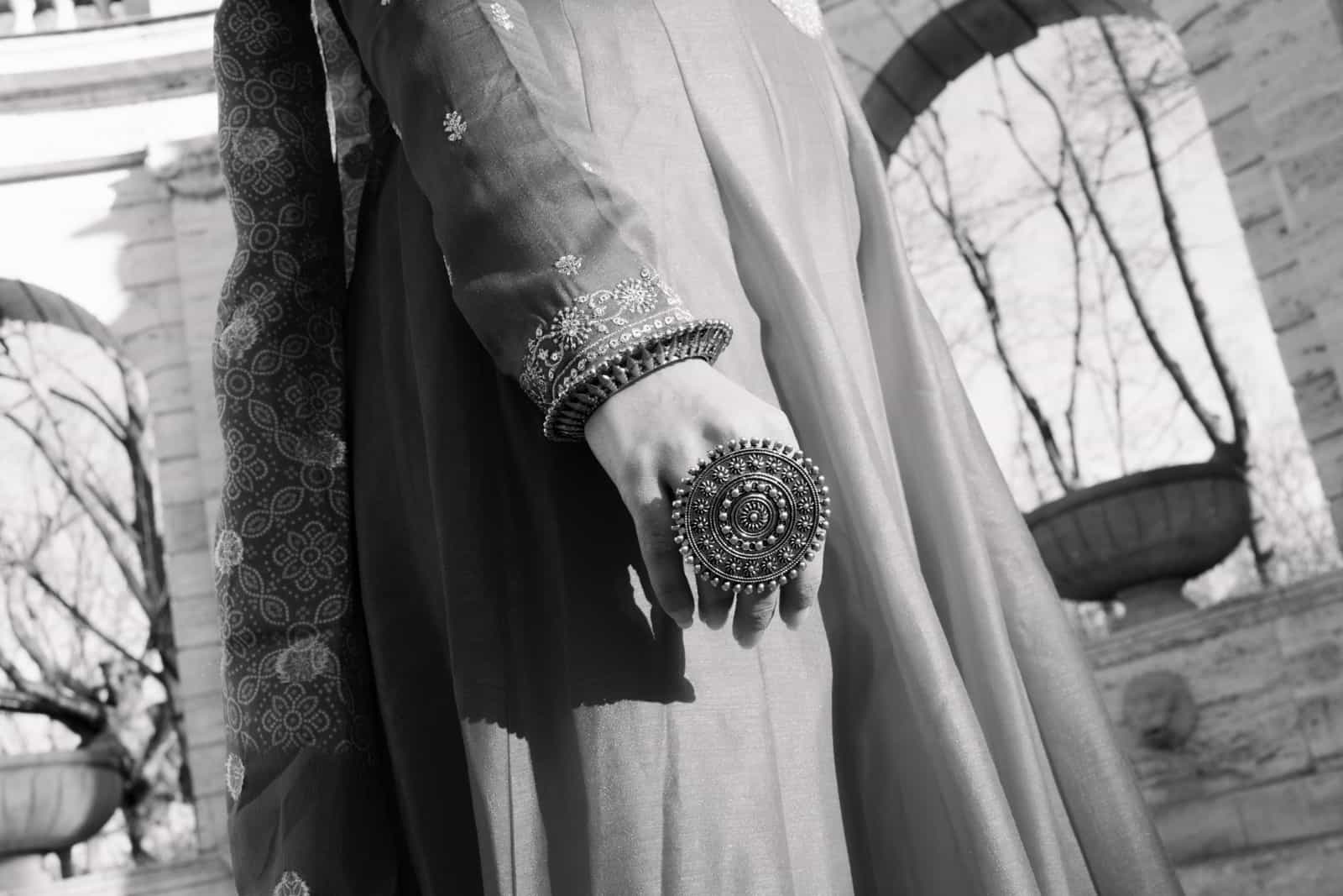 Große verzierter Ring und silberne Armreifen an Hand der indischen Braut, Schwarzweiß