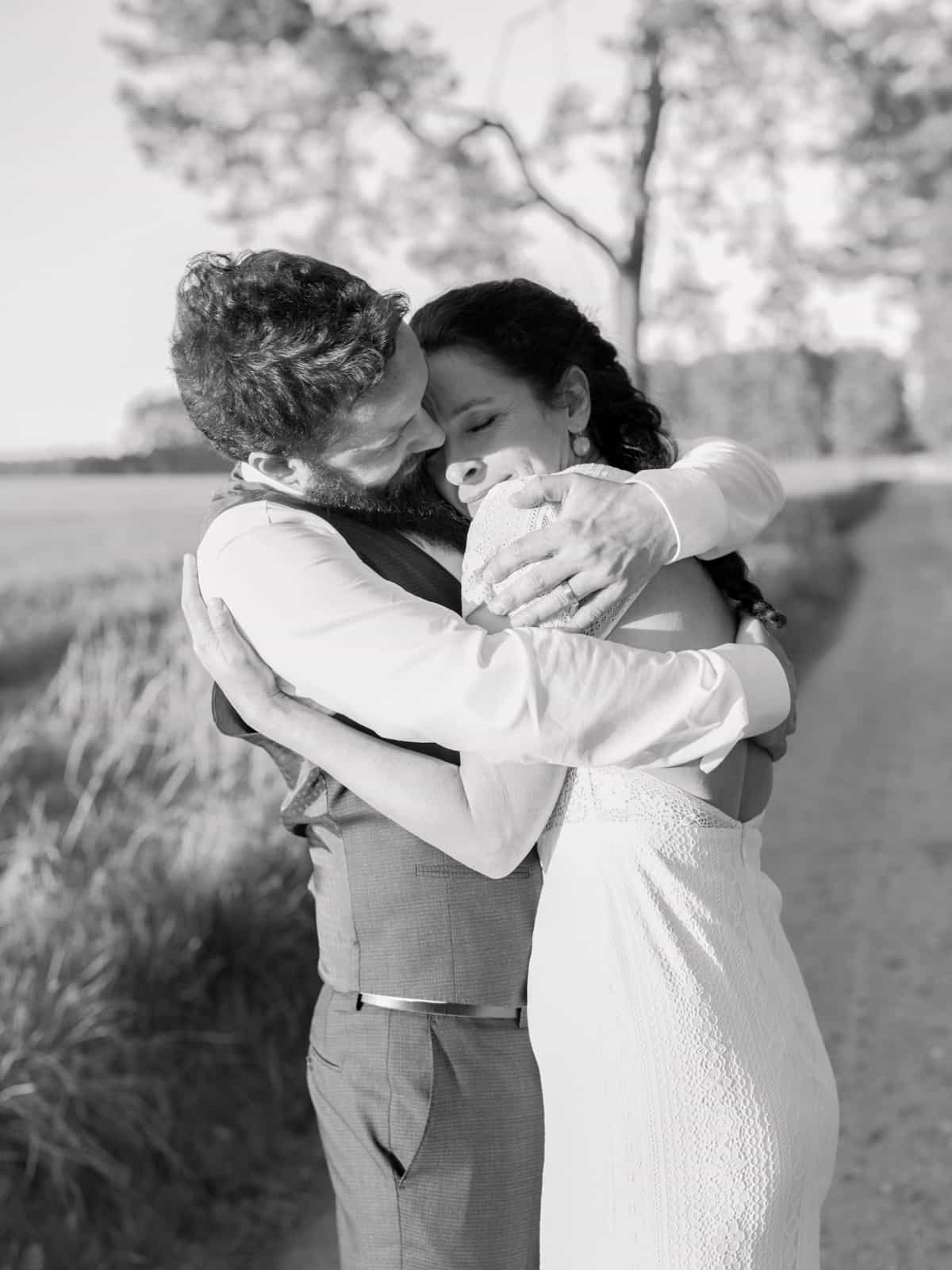 Happily laughing bride in intimate embrace in black and white