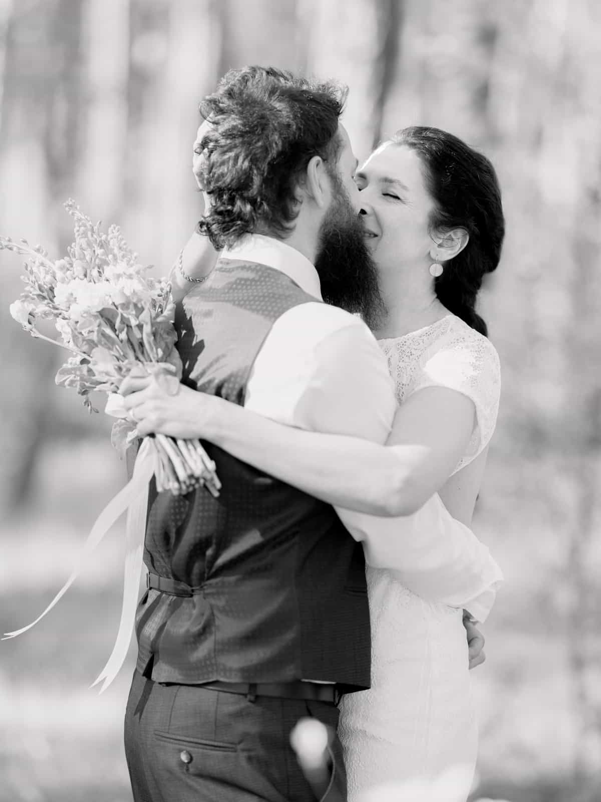 Bride holding wild bouquet with white and yellow flowers