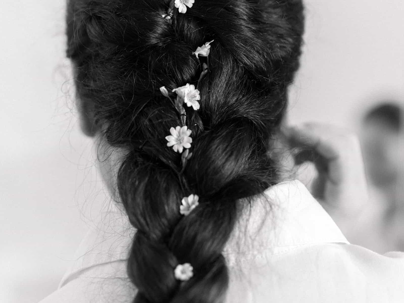 Detail shot of braided bridal hairstyle with small white flowers