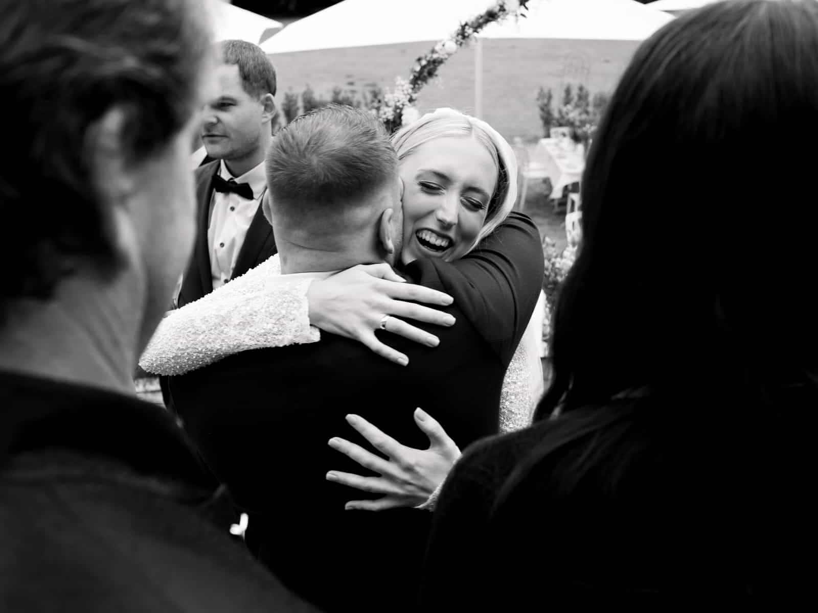 Bride embracing guest at Schloss Kartzow wedding, emotional congratulations after outdoor ceremony