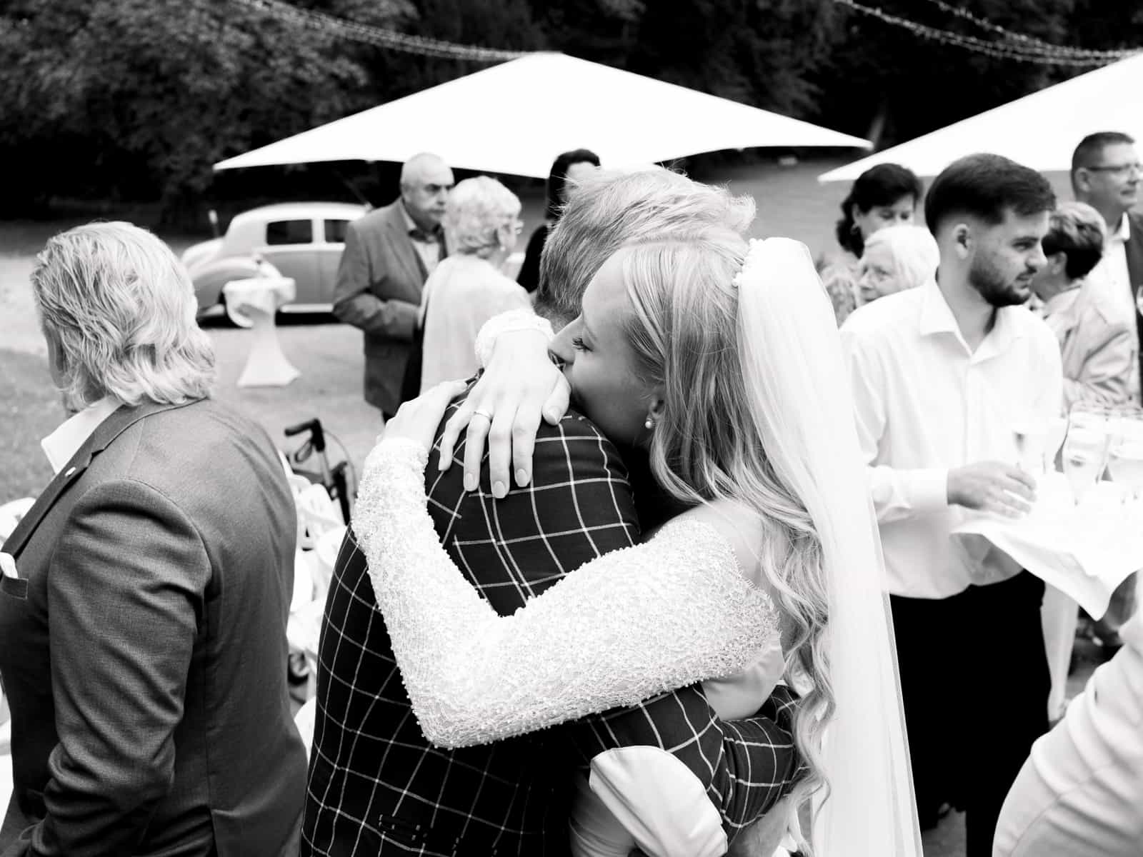 Bride being congratulated by guests after wedding at Schloss Kartzow in black and white
