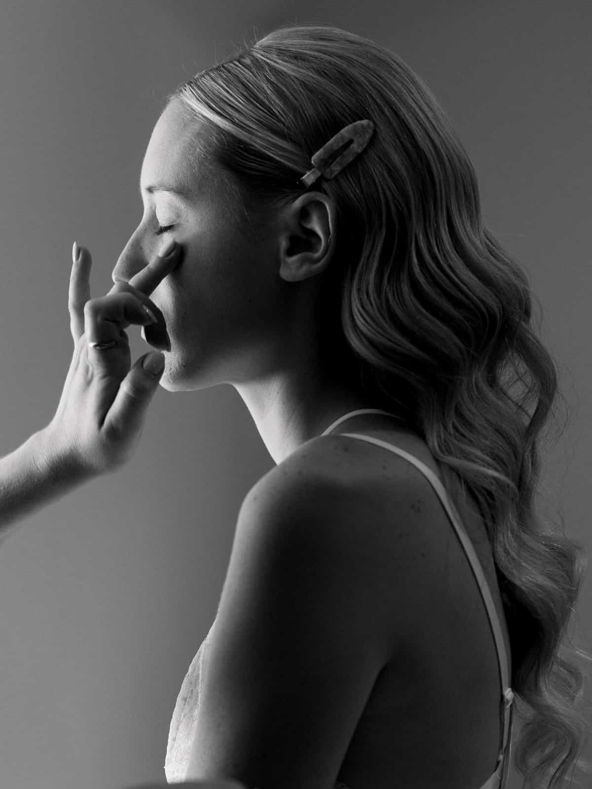 Bride in wedding dress looking aside during getting ready preparations, black and white wedding photography Schloss Kartzow