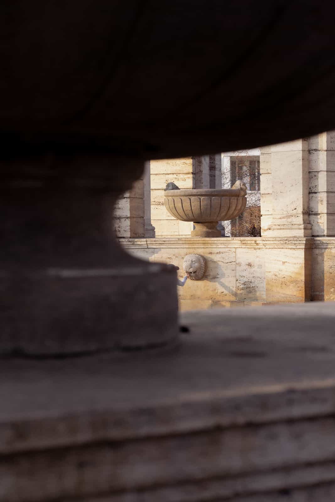 View through classical pavilion to lion head fountain