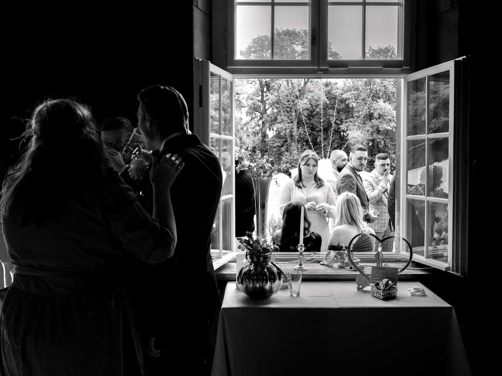 Castle wedding photography Schloss Kartzow - couple kissing at window with wedding guests in background Berlin Brandenburg