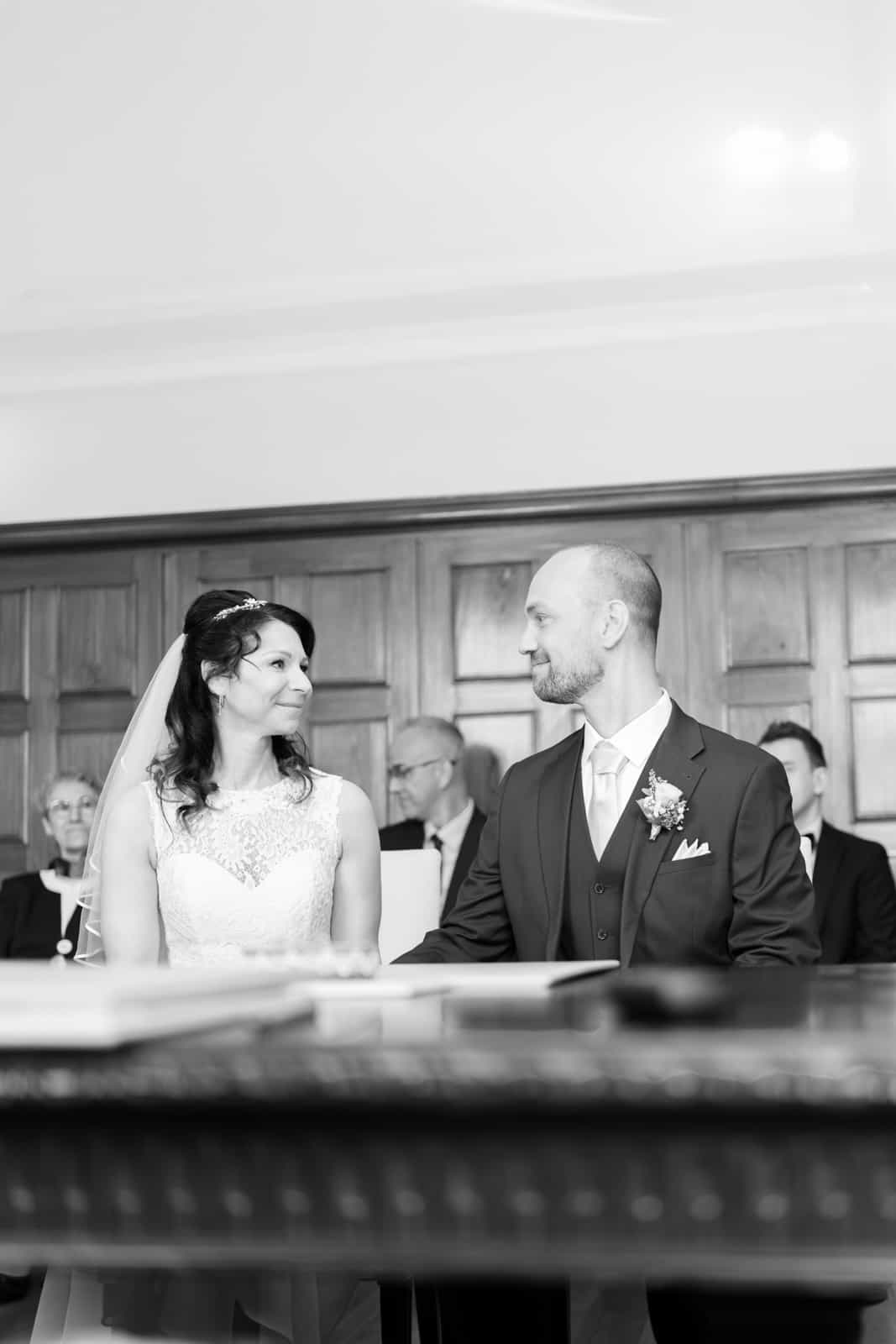 Couple looking lovingly into each other's eyes at ceremony, black and white
