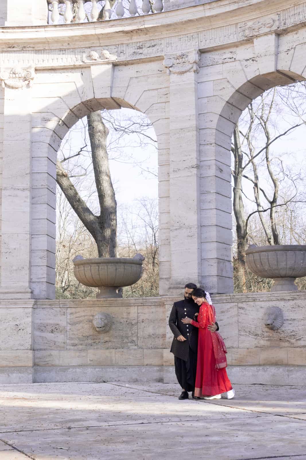 Couple embracing under grand neoclassical colonnade with urns
