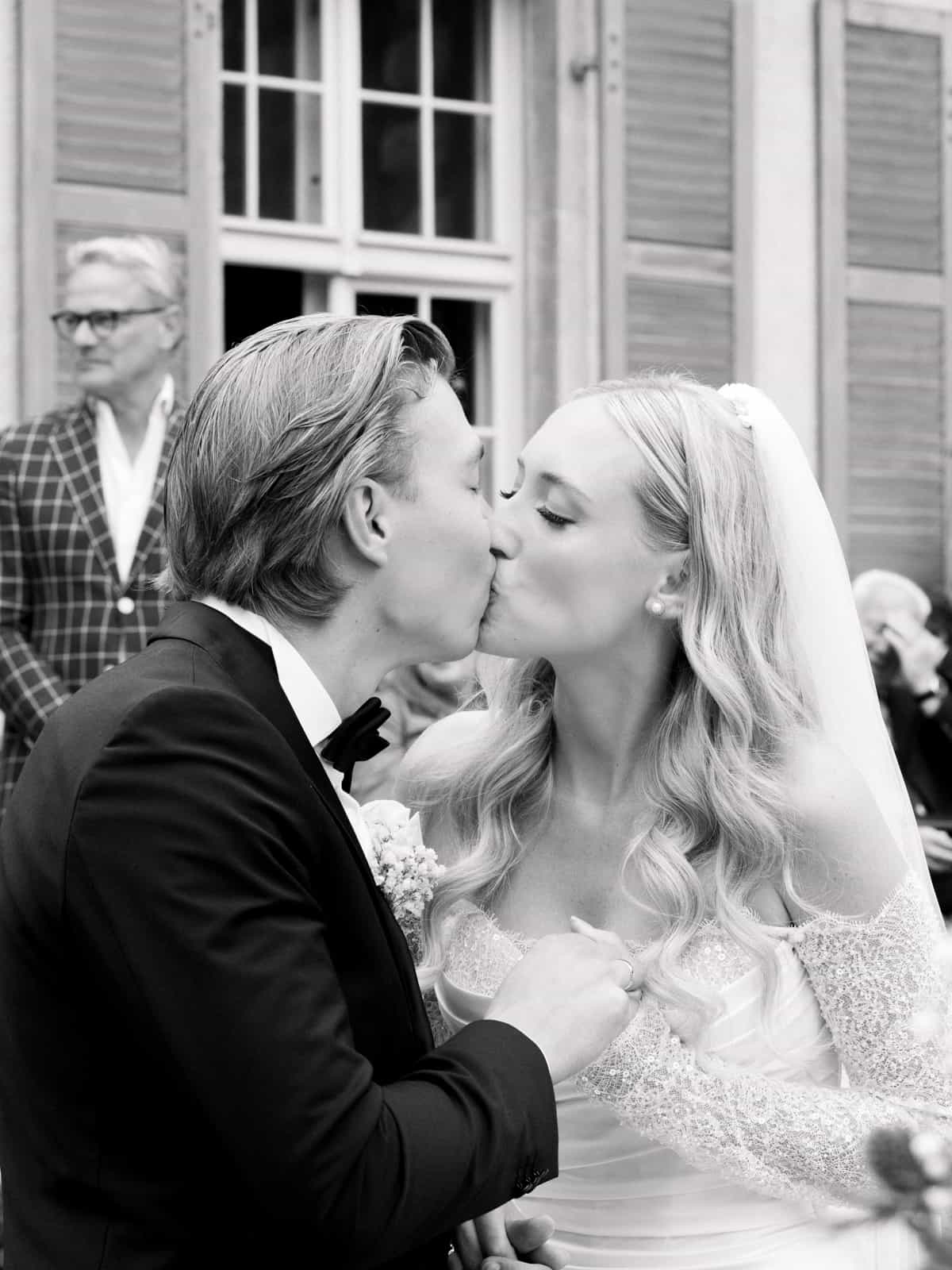 Wedding couple kissing for the first time as married couple at Schloss Kartzow in black and white