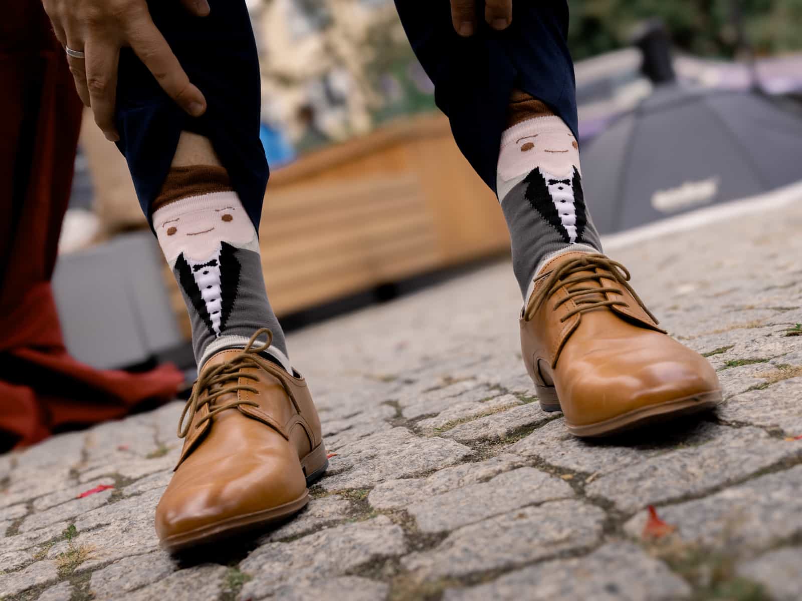 Groom presenting funny socks with tuxedo design