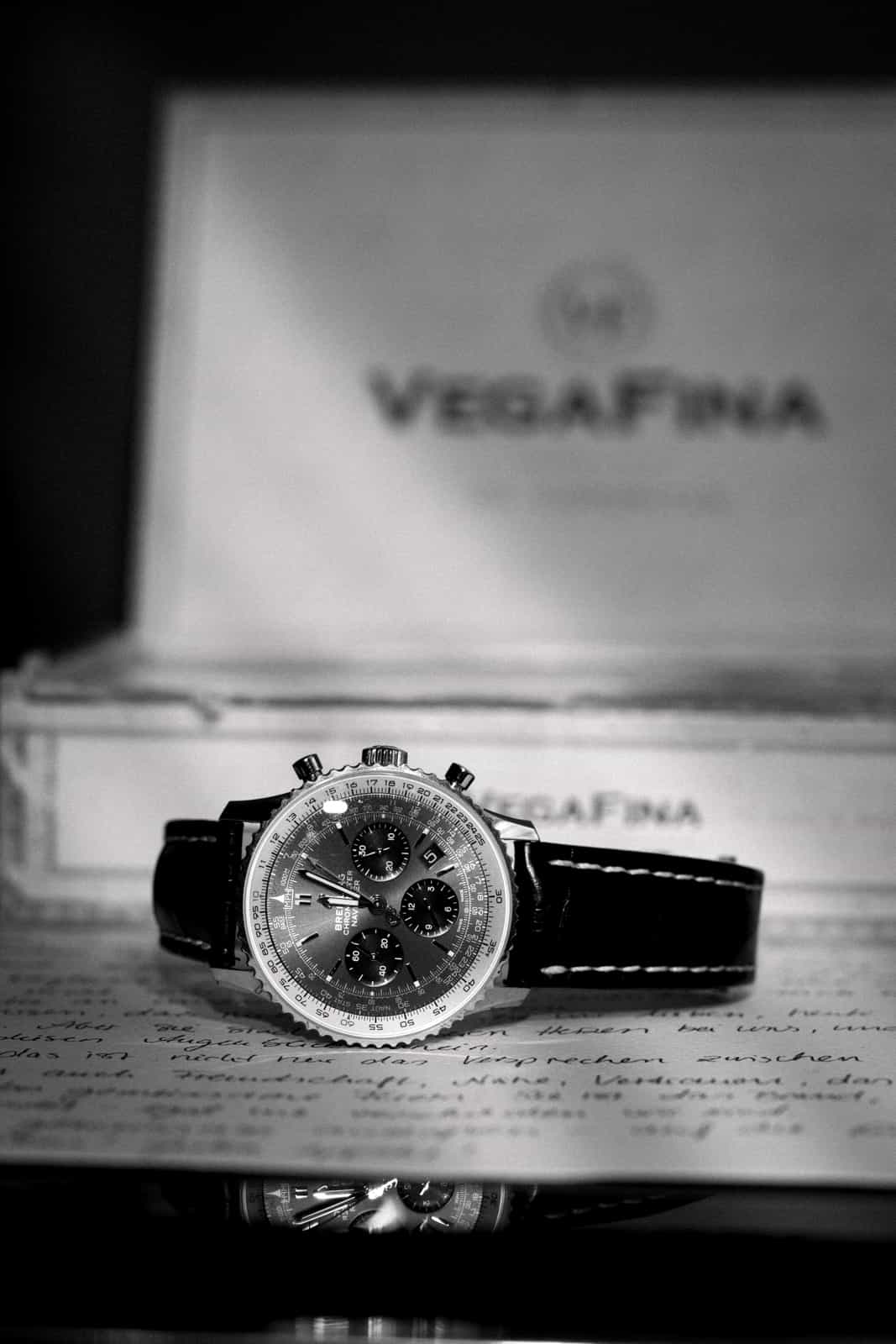 Breitling watch on handwritten letter with cigar box, groom details black and white