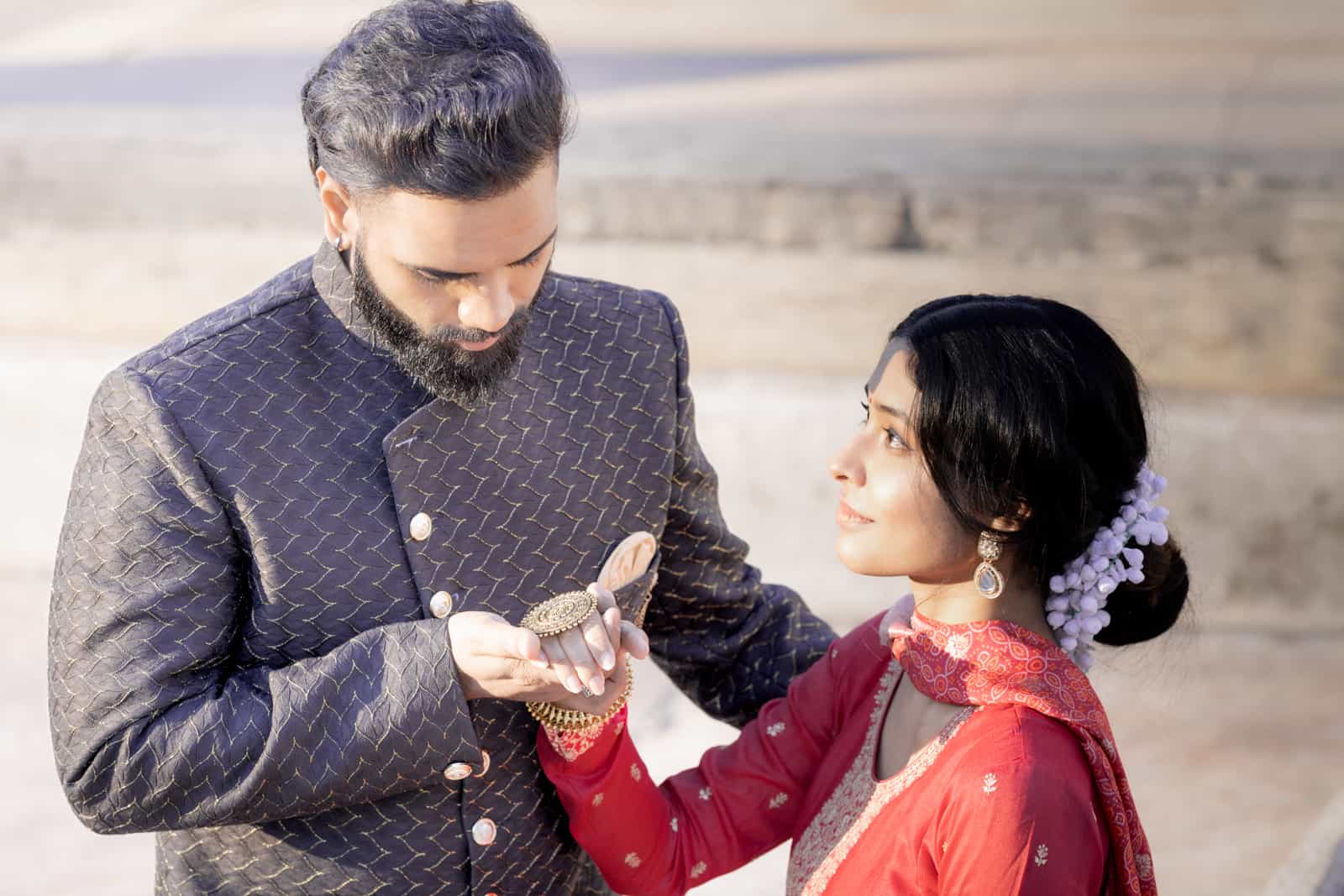 Indian groom looking at bride's bangles with flowers in her hair