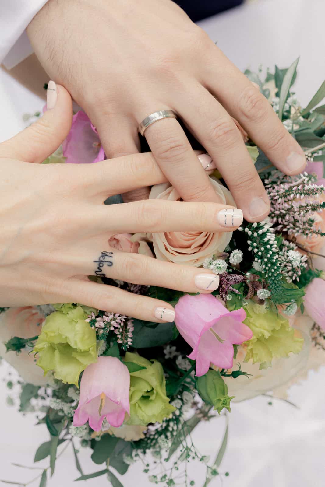 Silver cufflink on groom's white shirt cuff, black and white