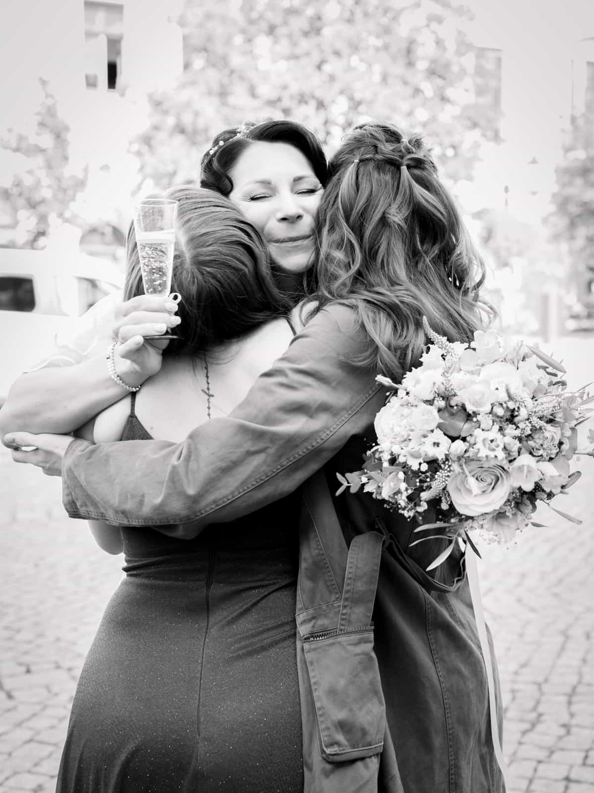 Bride being congratulated by friends in group hug