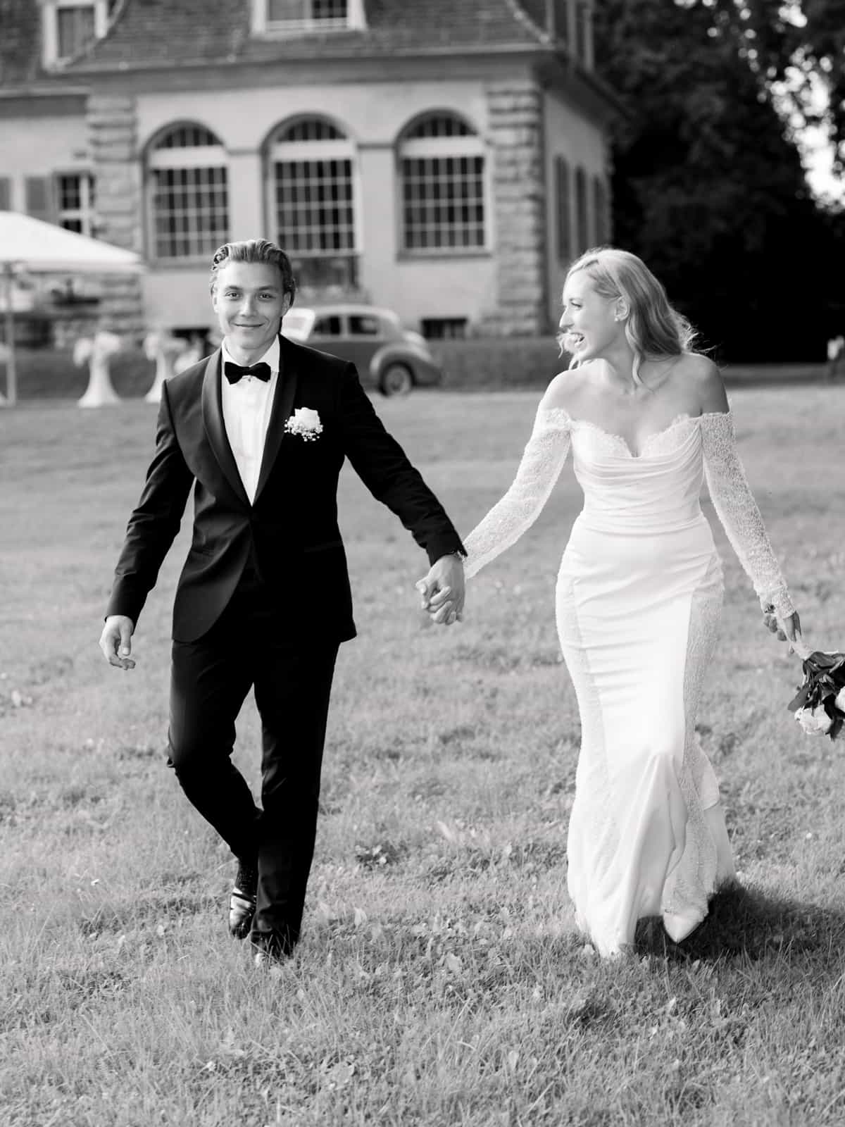 Wedding couple laughing happily in front of Schloss Kartzow at glamorous castle wedding
