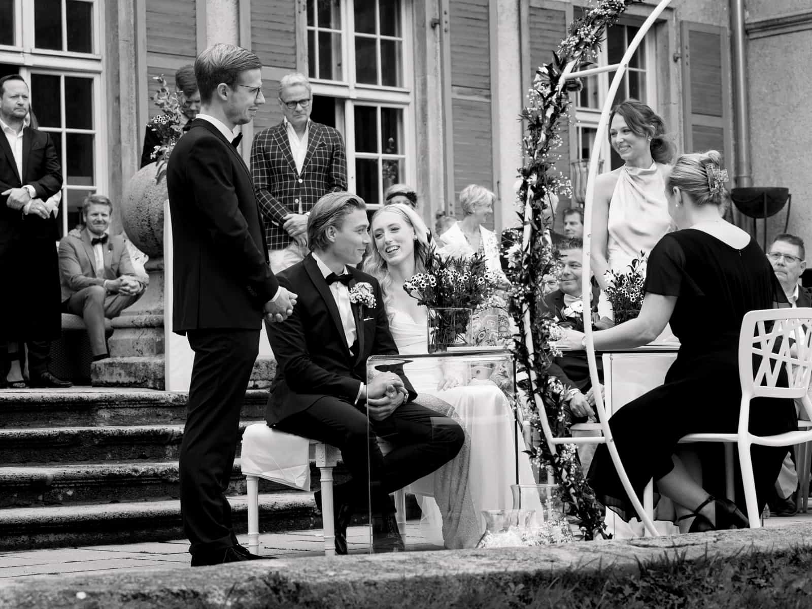 Wedding couple smiling during wedding ceremony at Schloss Kartzow in black and white