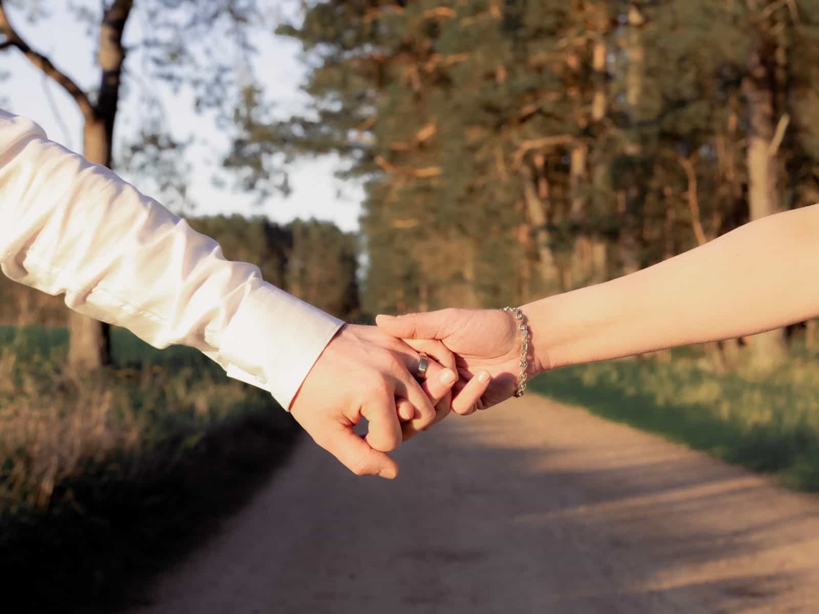 Couple's intertwined hands in warm evening light