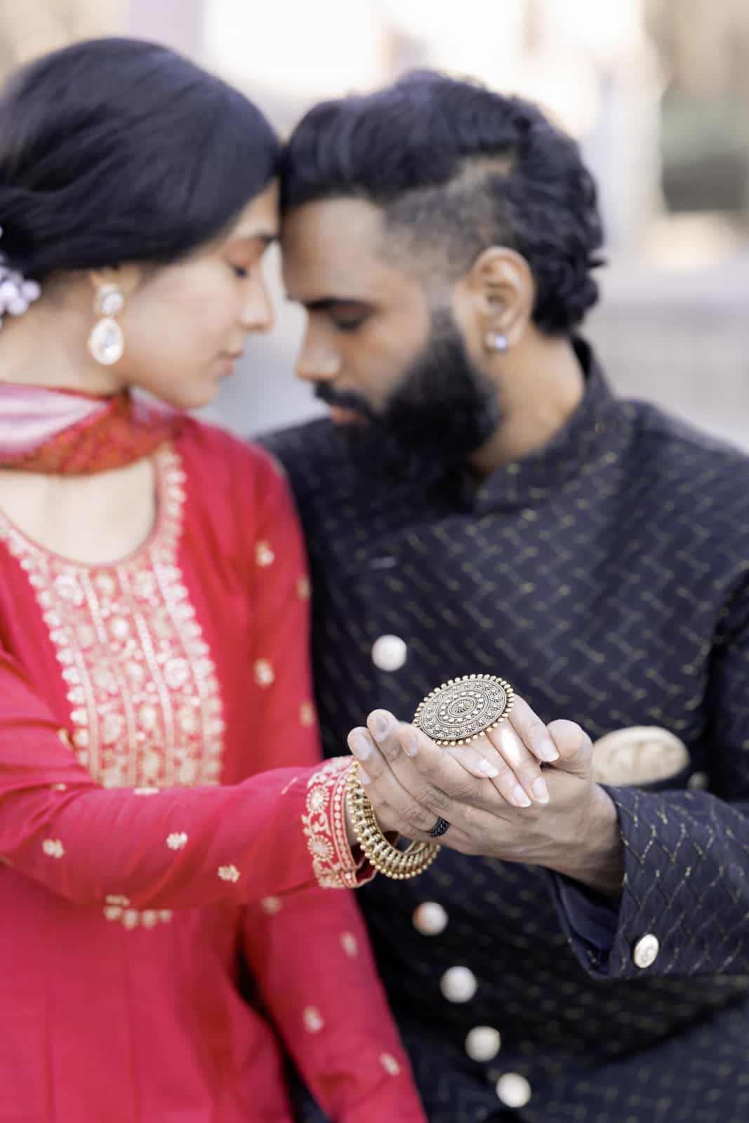 Indian couple forehead to forehead with focus on traditional jewelry