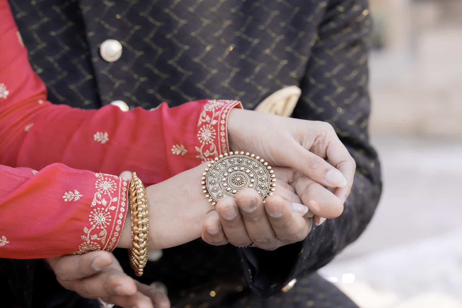 Interlocked hands with ornate ring and gold bracelet