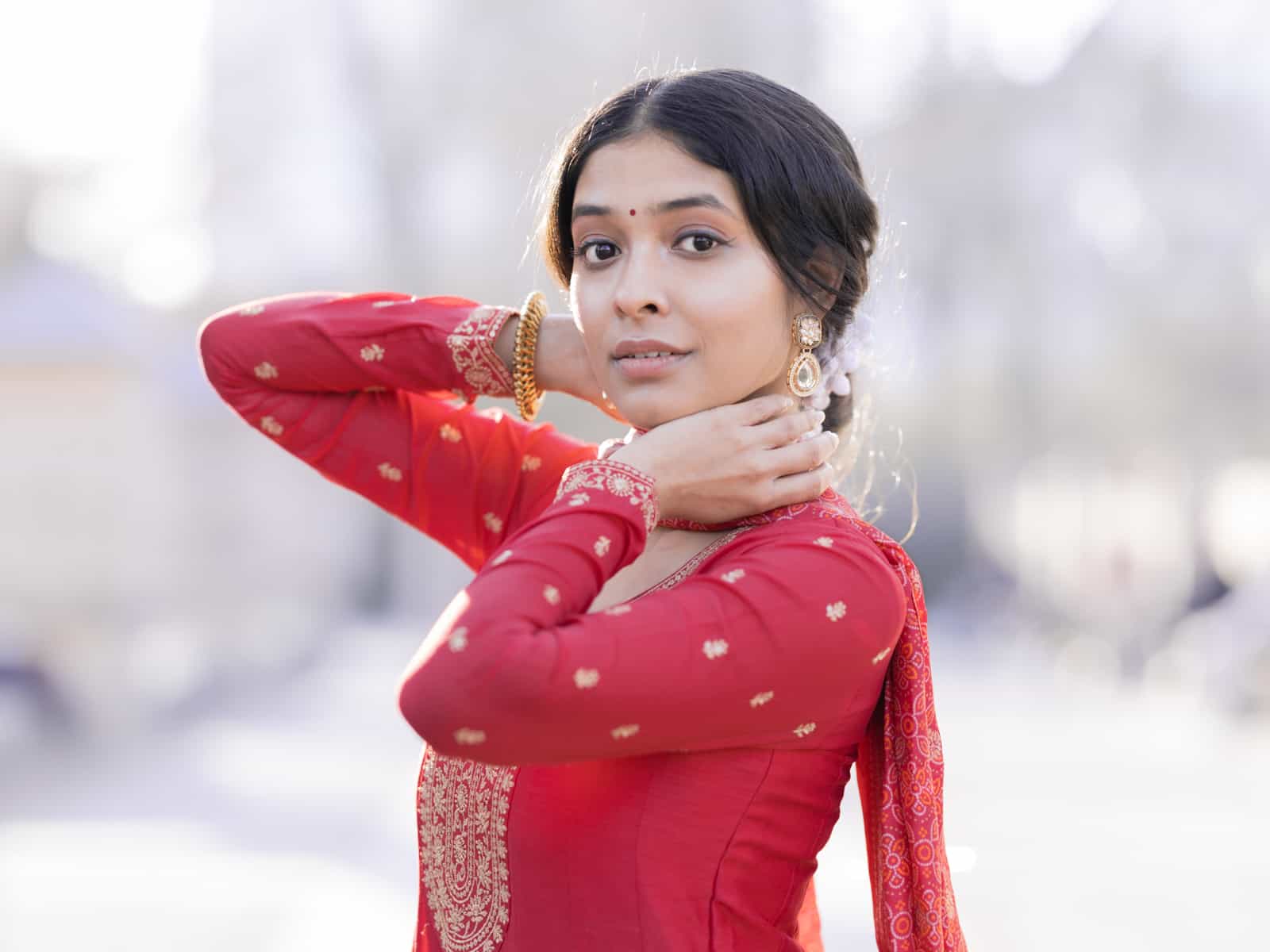 Indian bridal couple in intimate embrace under trees