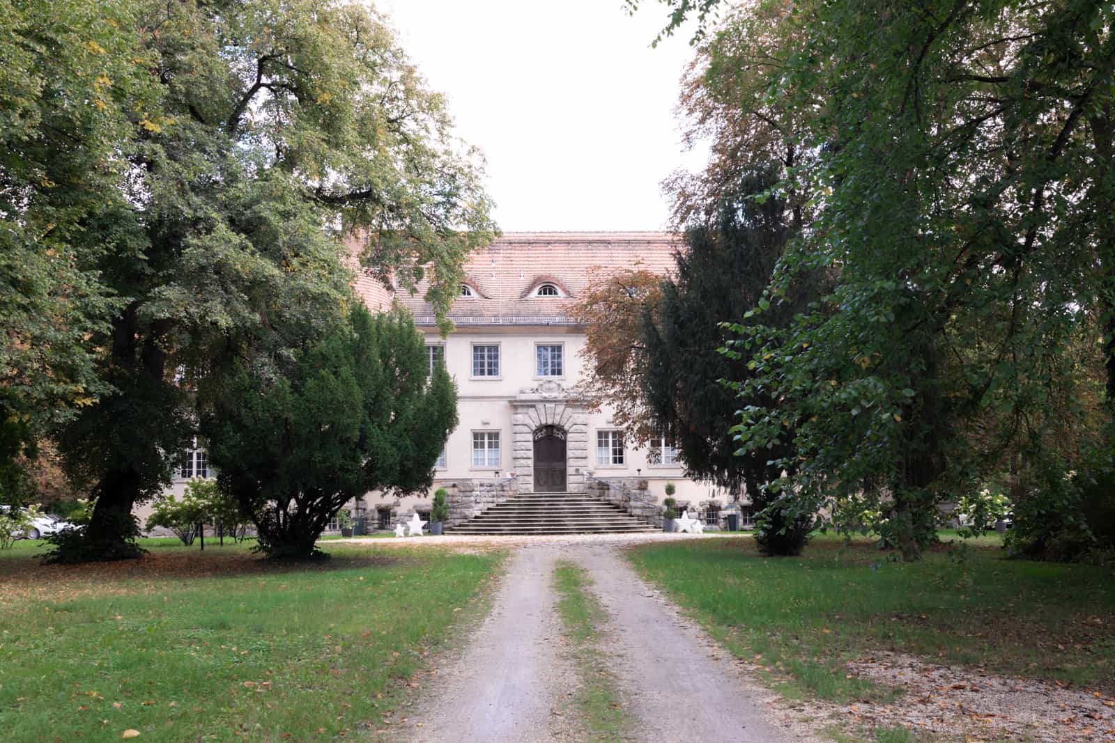 Stately manor house with tree-lined driveway as elegant wedding venue