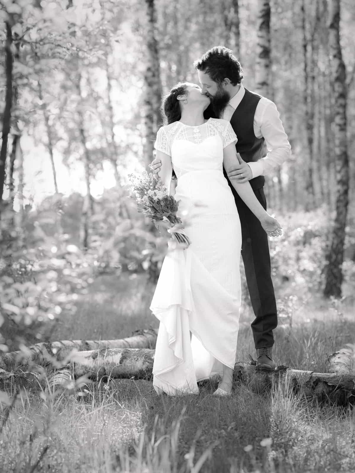 Couple kissing tenderly in sunny birch forest