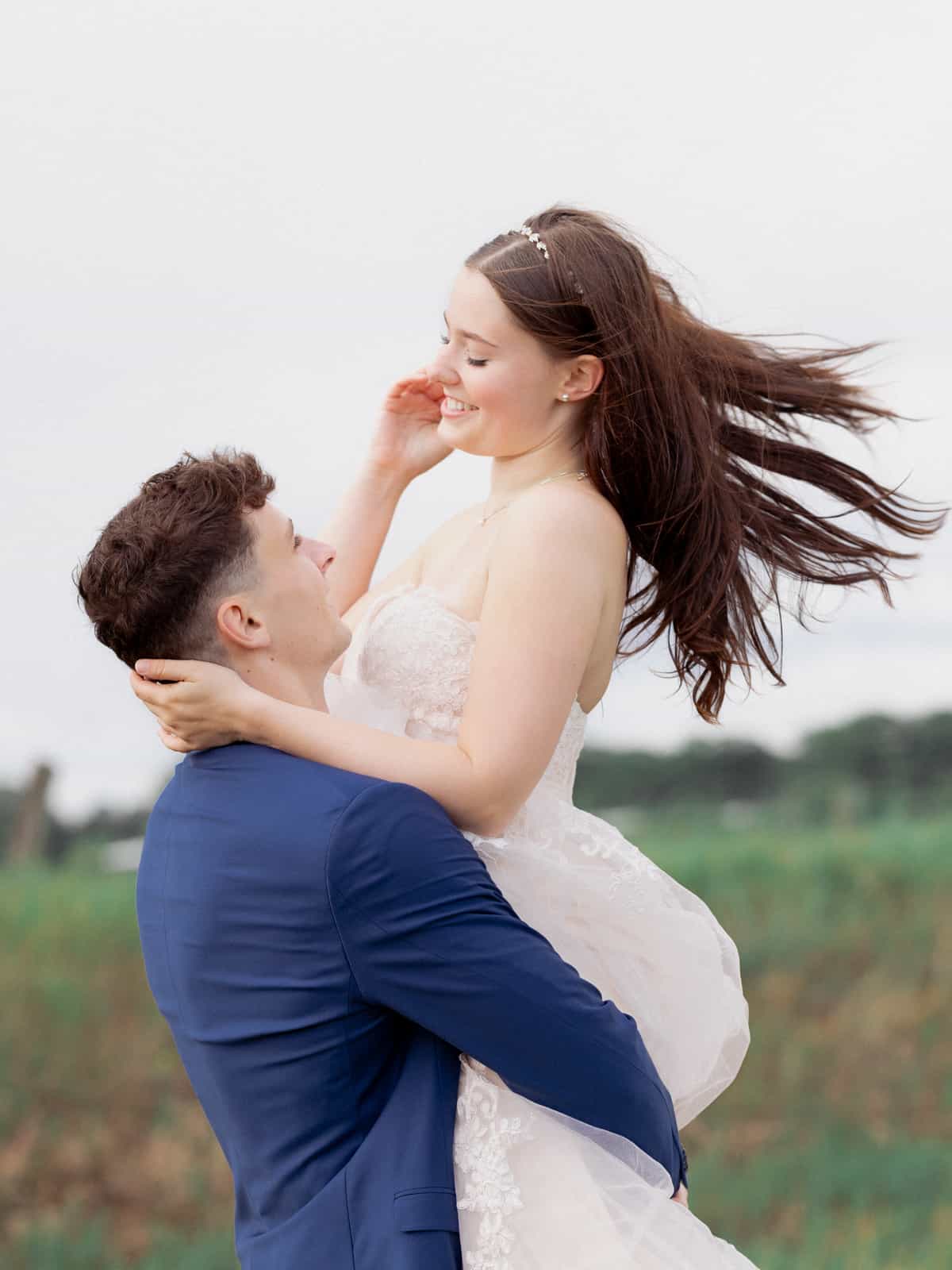 Groom lifting bride and spinning her in flowing movement
