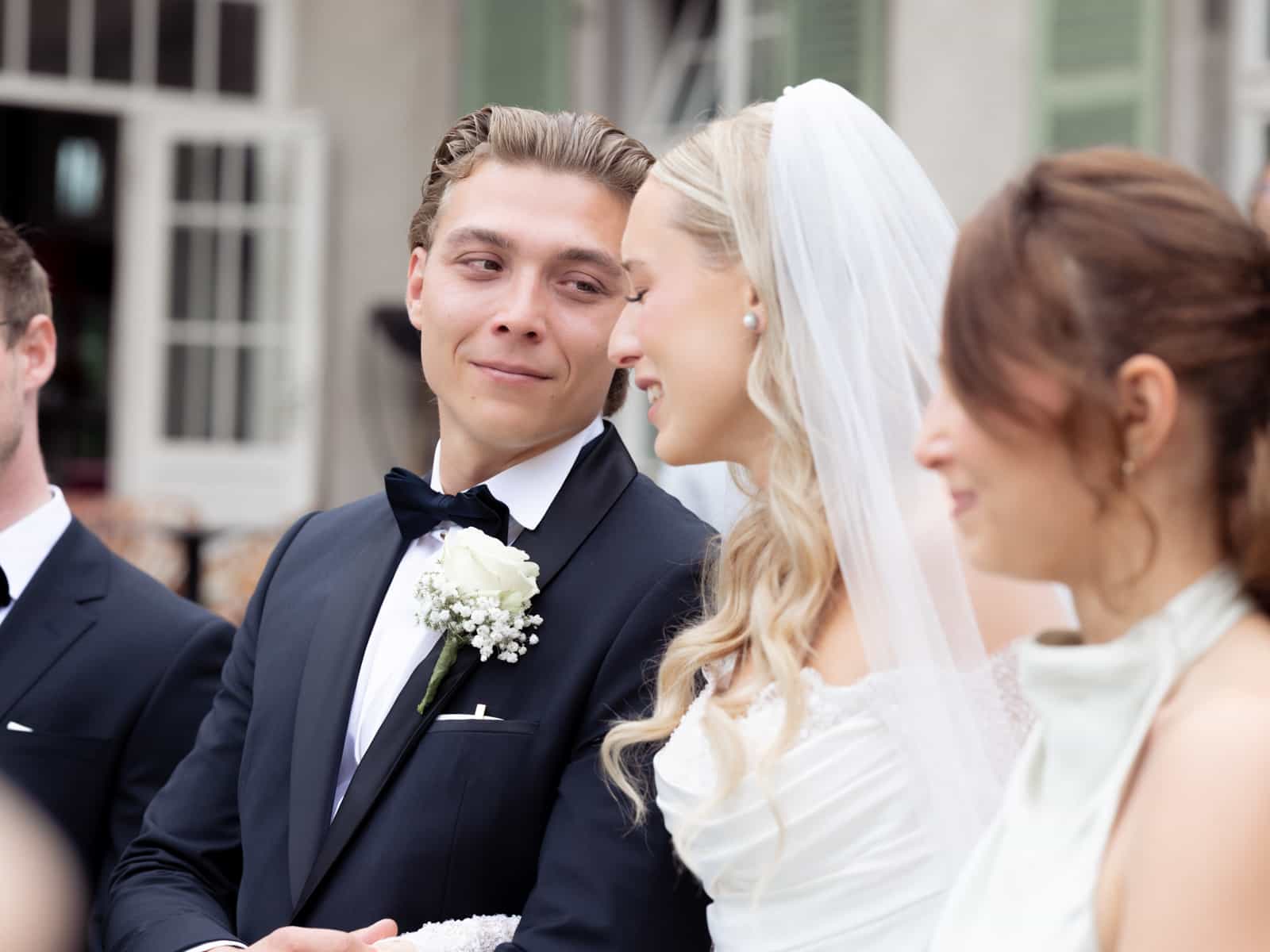 Groom looking aside during wedding ceremony at Schloss Kartzow with bride and guests