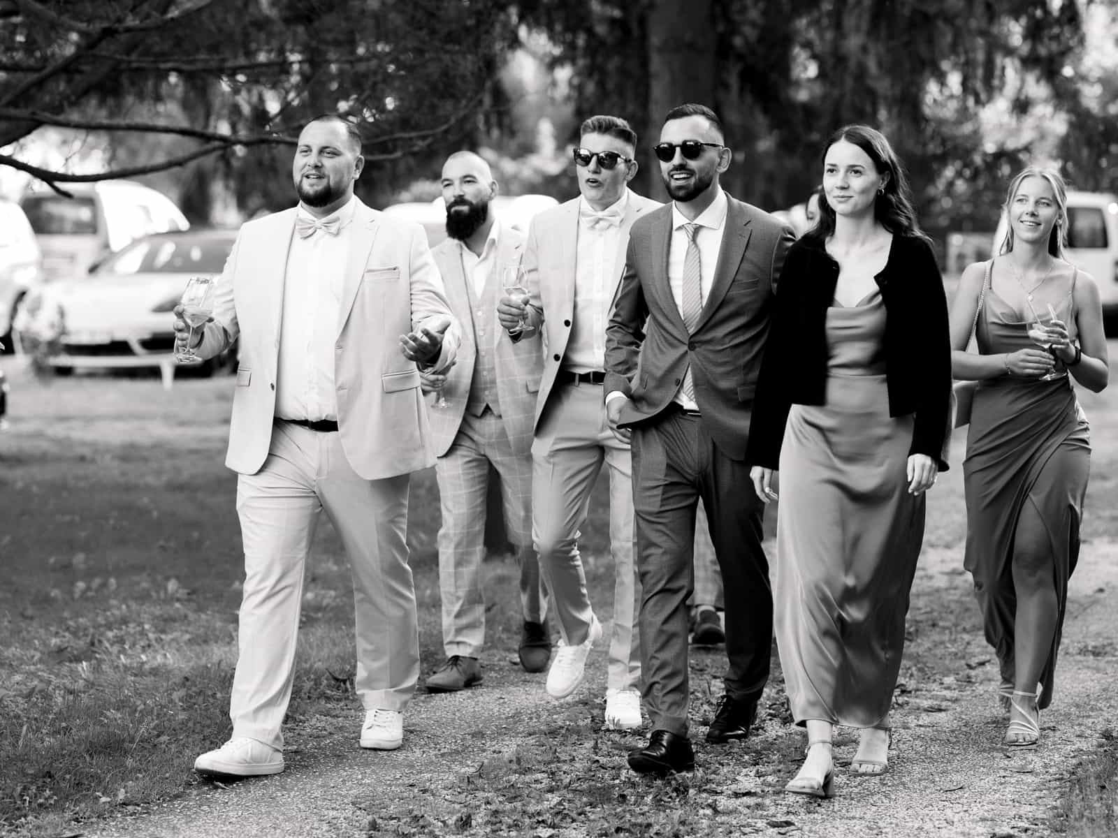 Group of elegant wedding guests in formal attire at Schloss Kartzow gardens