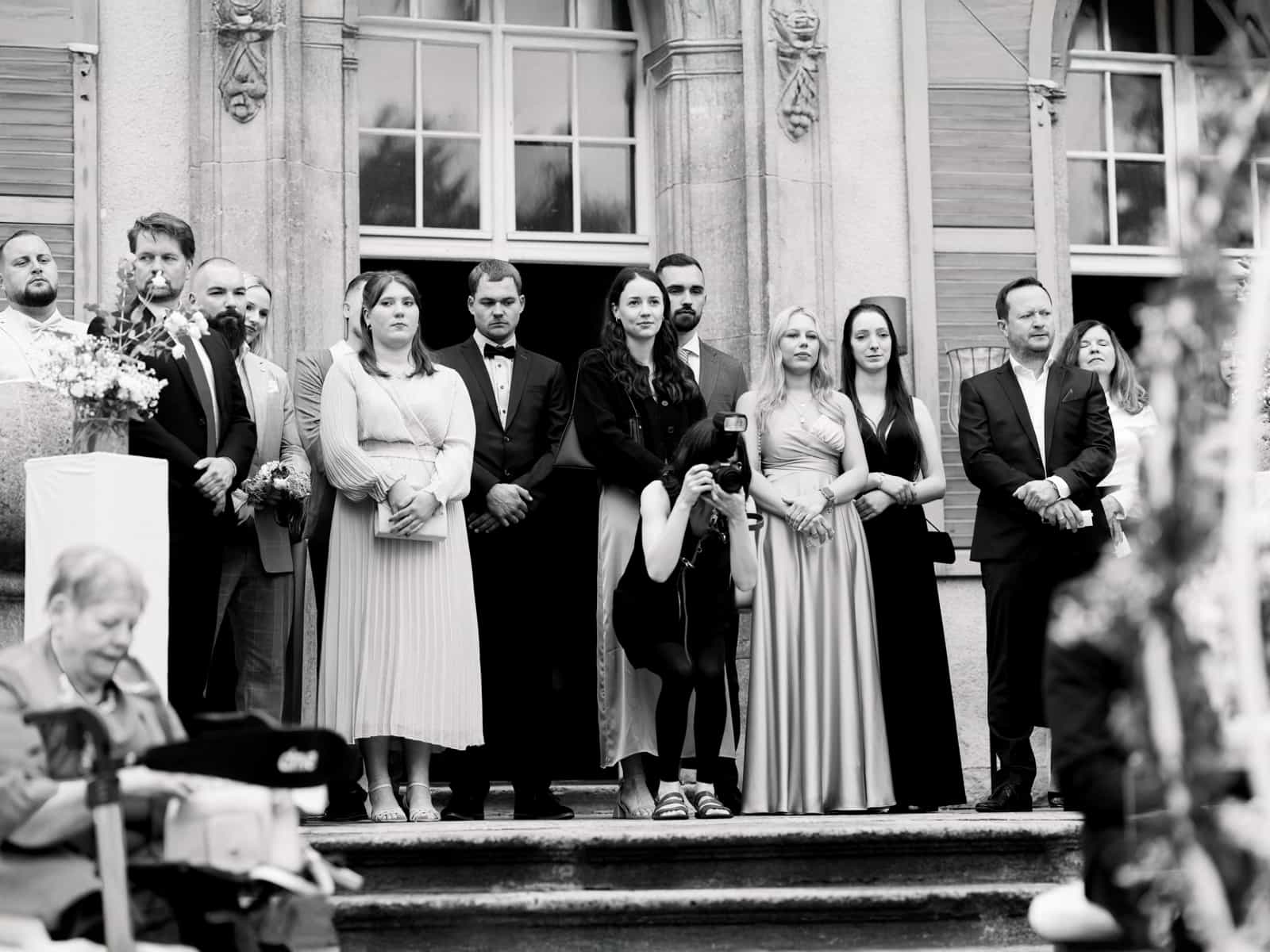Castle wedding photography Schloss Kartzow - wedding guests on castle steps during ceremony Berlin Brandenburg
