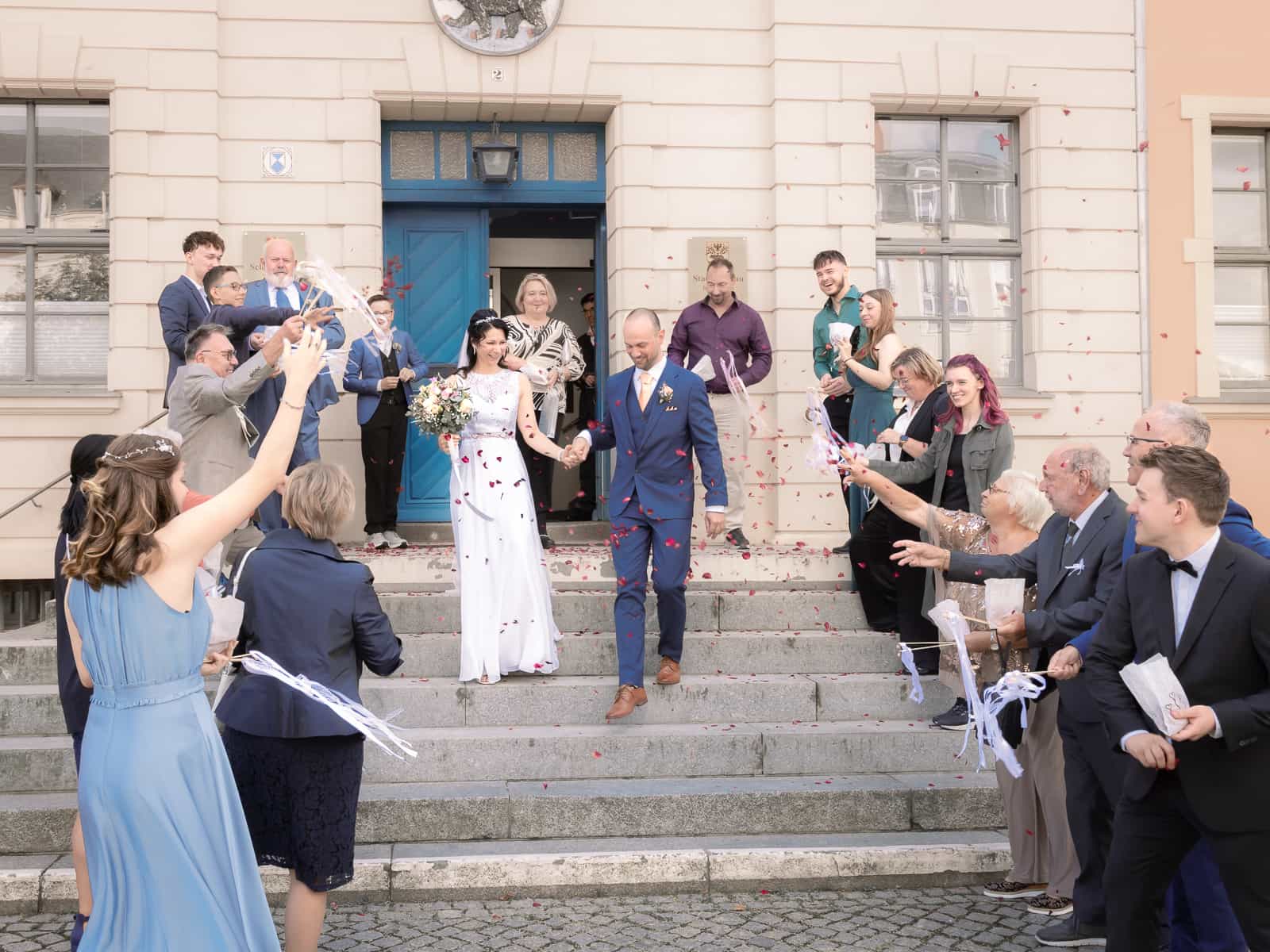 Wedding party throwing confetti in front of church