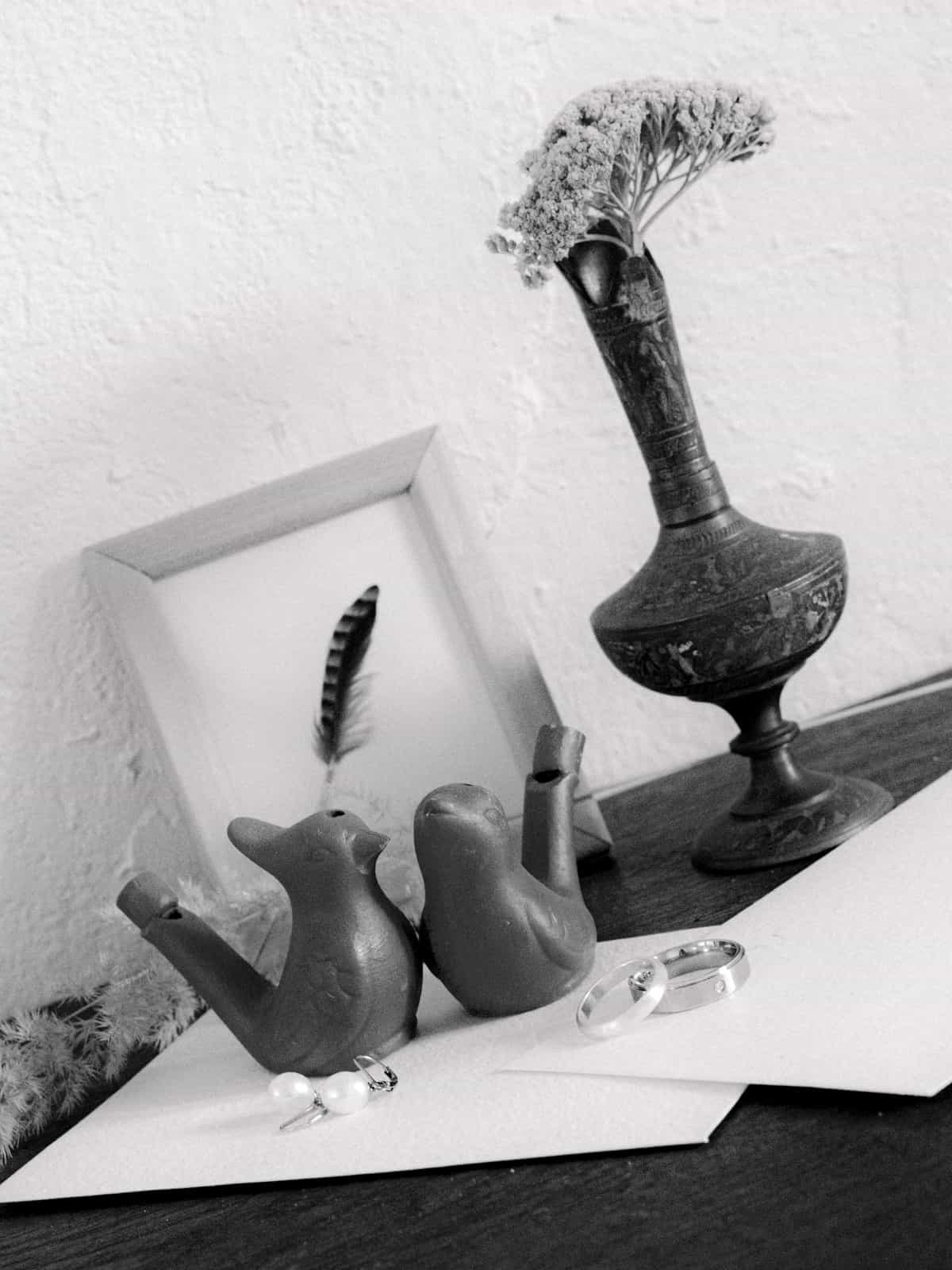 Wedding rings with bird decoration and flowers in black and white