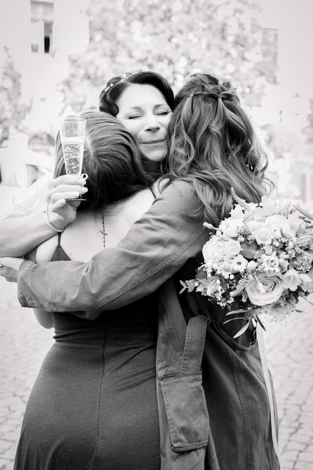 Hands with wedding rings on bridal bouquet with pink and white roses