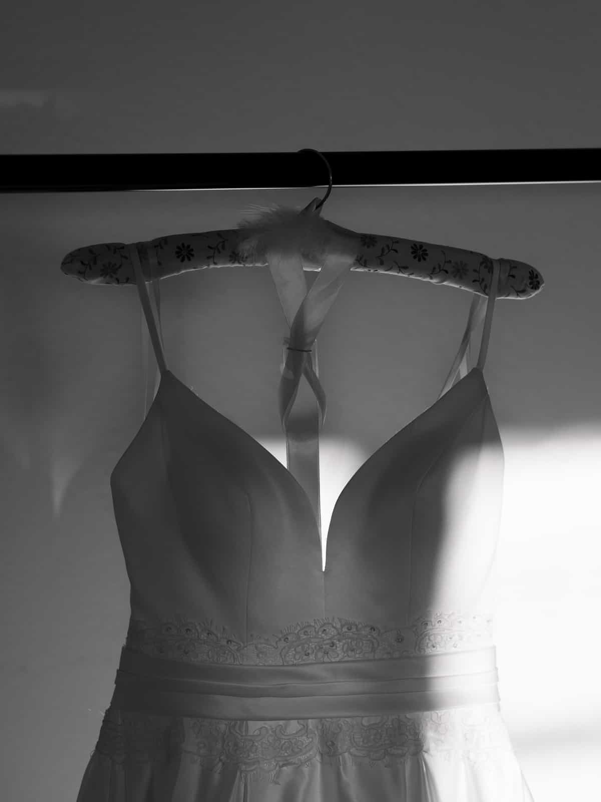Wedding dress with lace details on floral hanger in black and white