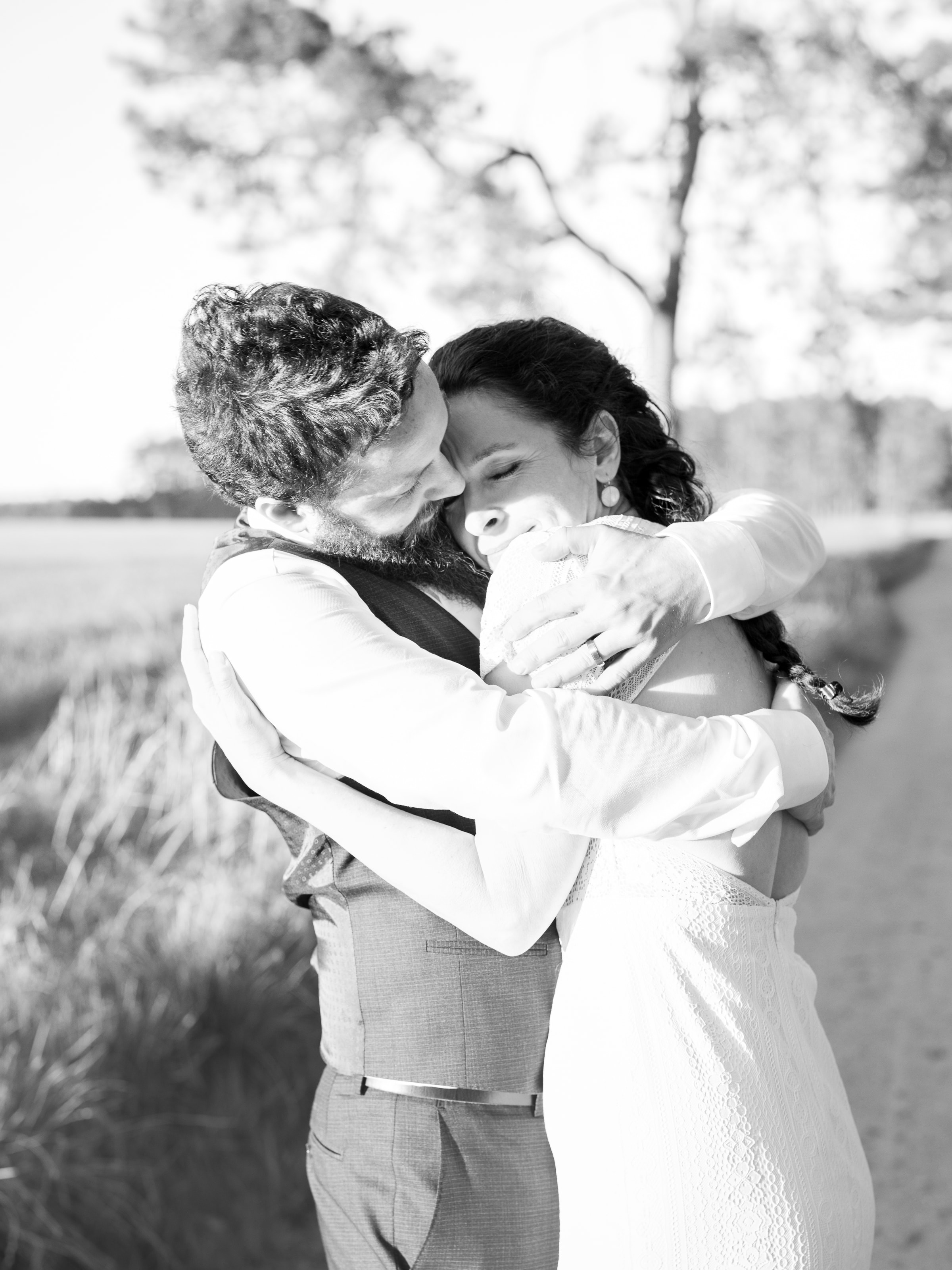 Happily laughing bride in intimate embrace in black and white