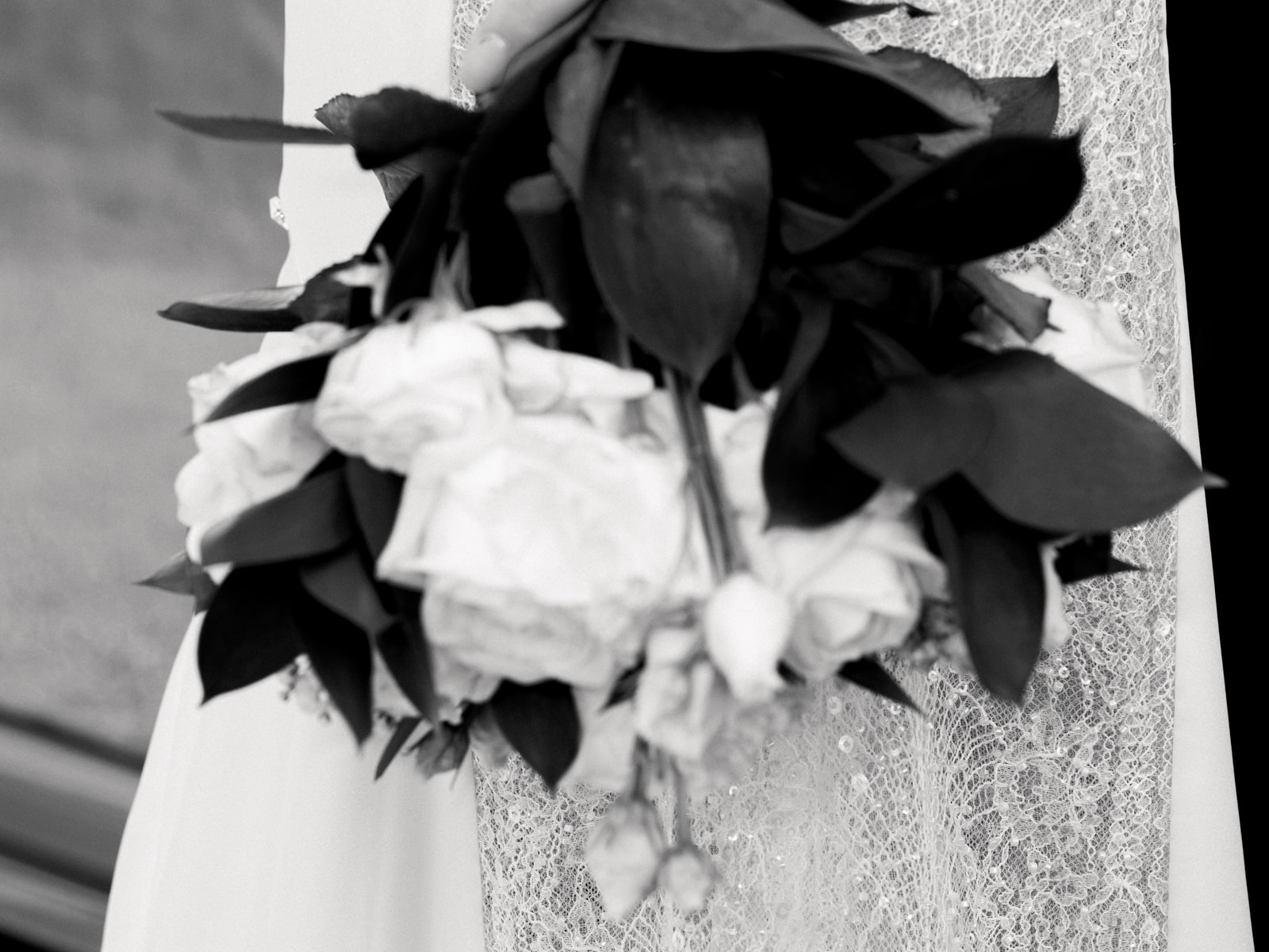 Close-up of bridal bouquet with white roses and lace dress at Schloss Kartzow castle wedding