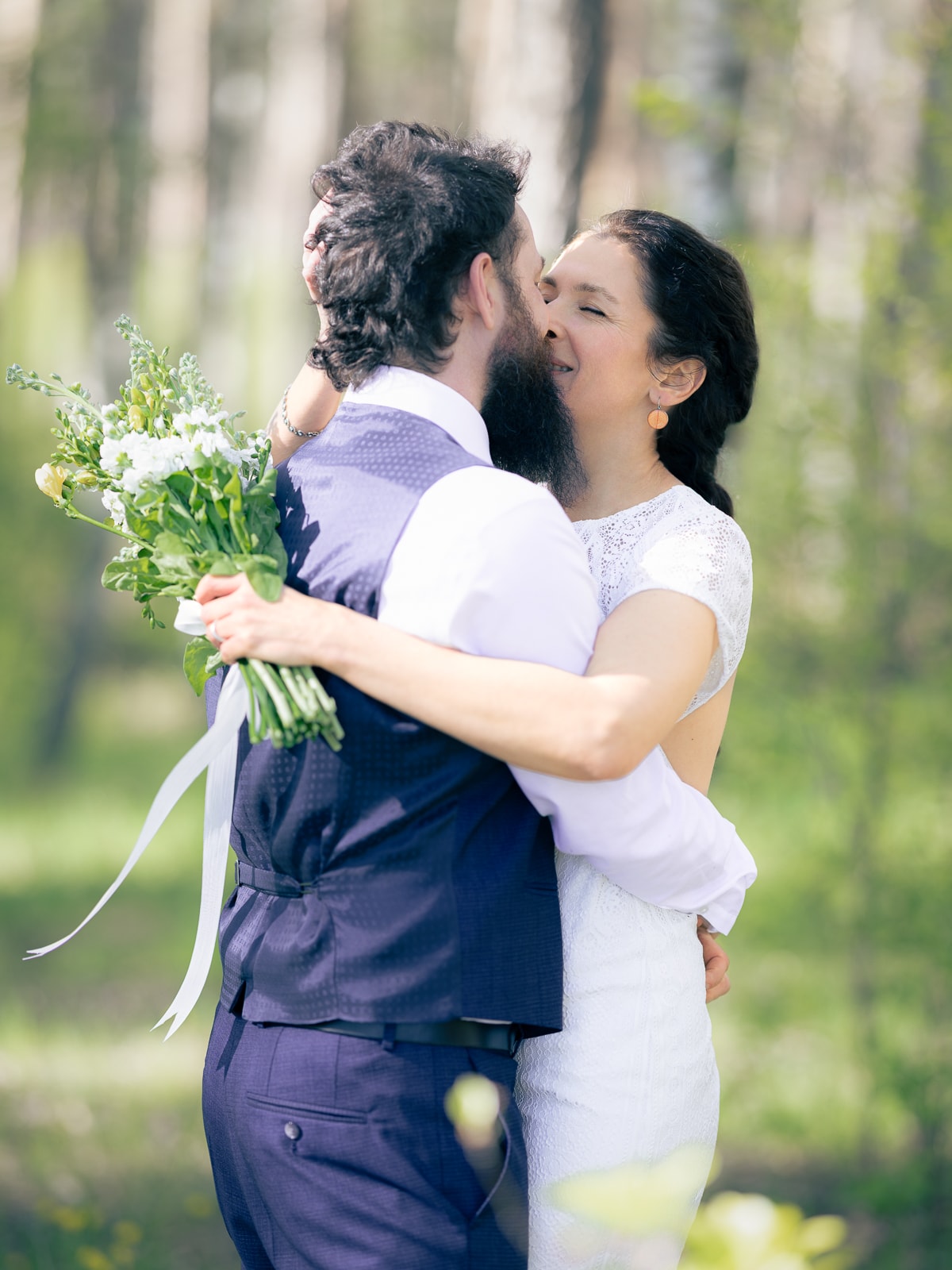 Bride holding wild bouquet with white and yellow flowers