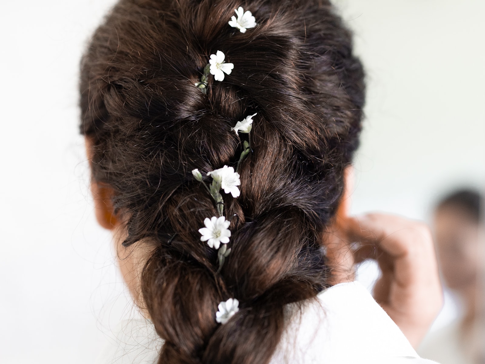 Detail shot of braided bridal hairstyle with small white flowers