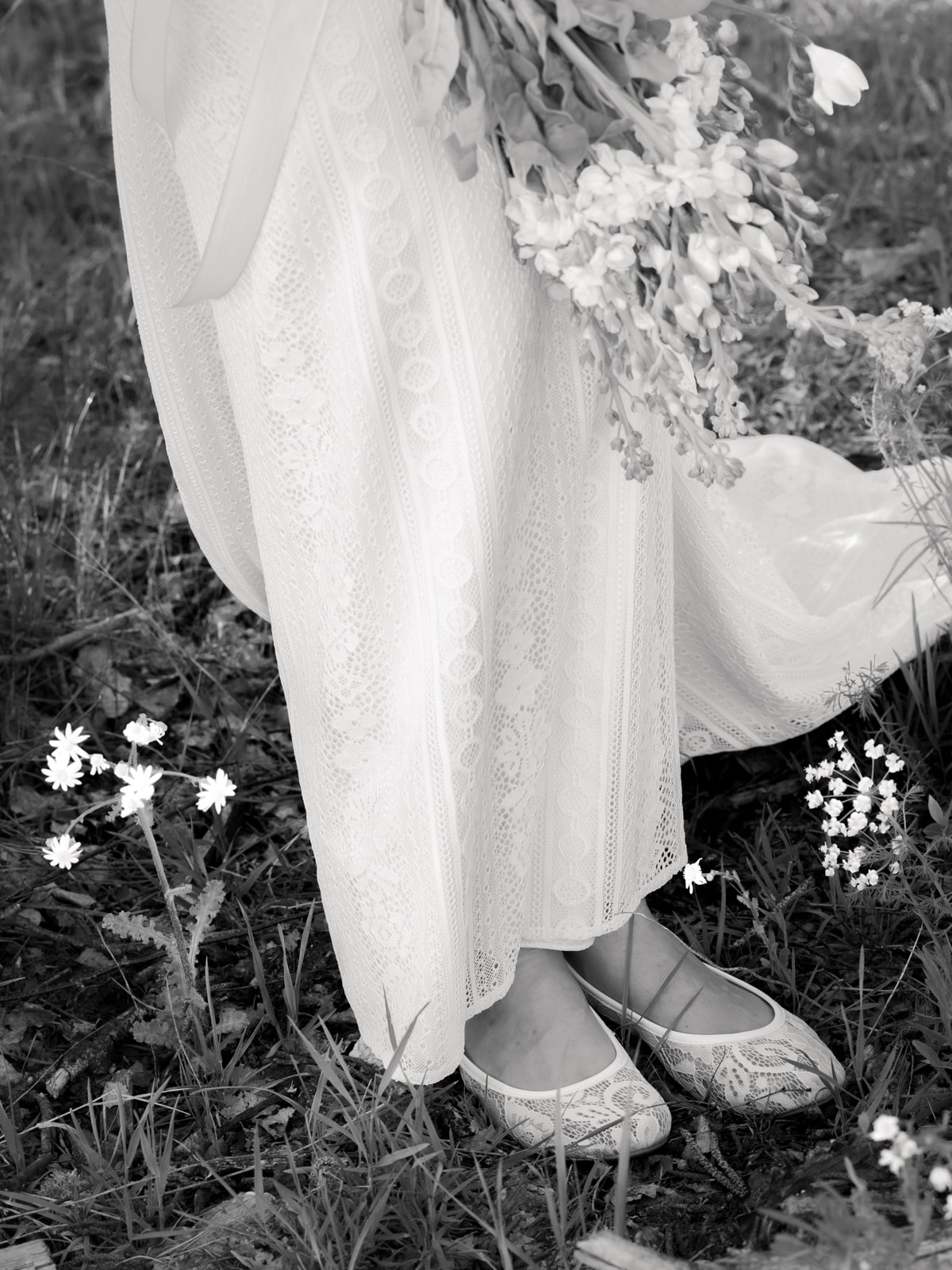 Bridal shoes with lace dress and wildflowers in black and white