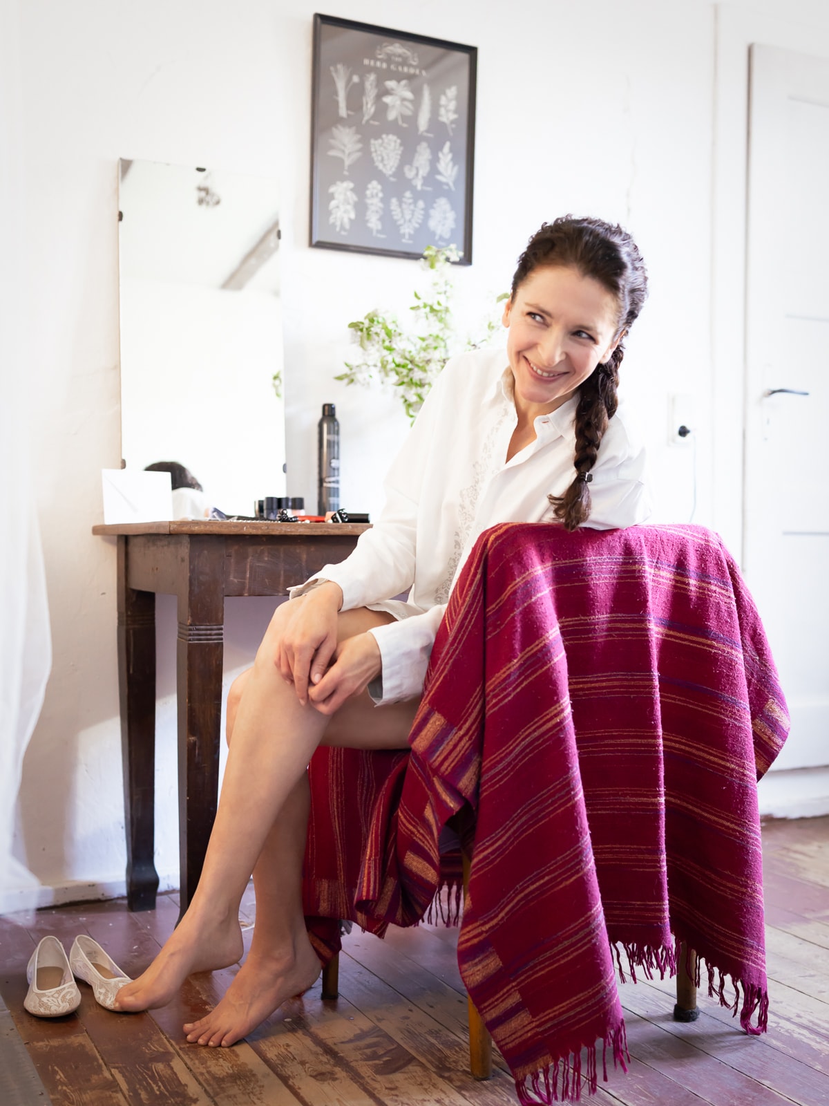 Smiling bride in white silk shirt during wedding preparations