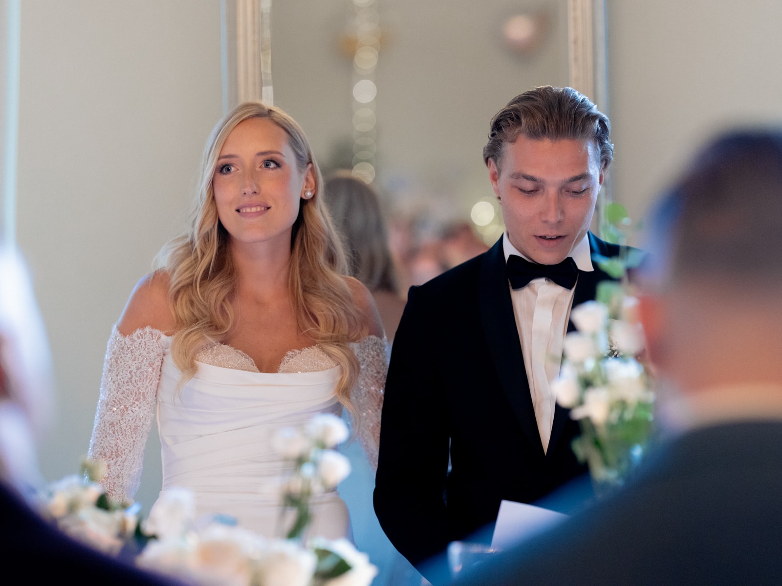 Bride and groom at wedding ceremony with bokeh lights in background - Schloss Kartzow wedding