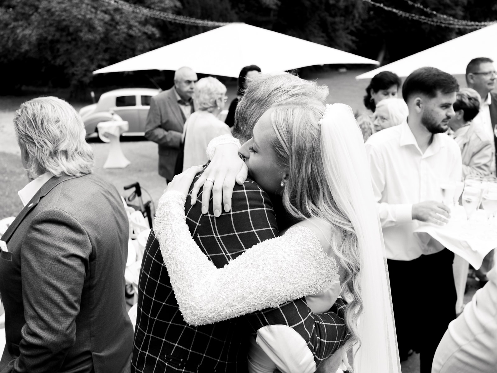 Bride being congratulated by guests after wedding at Schloss Kartzow in black and white