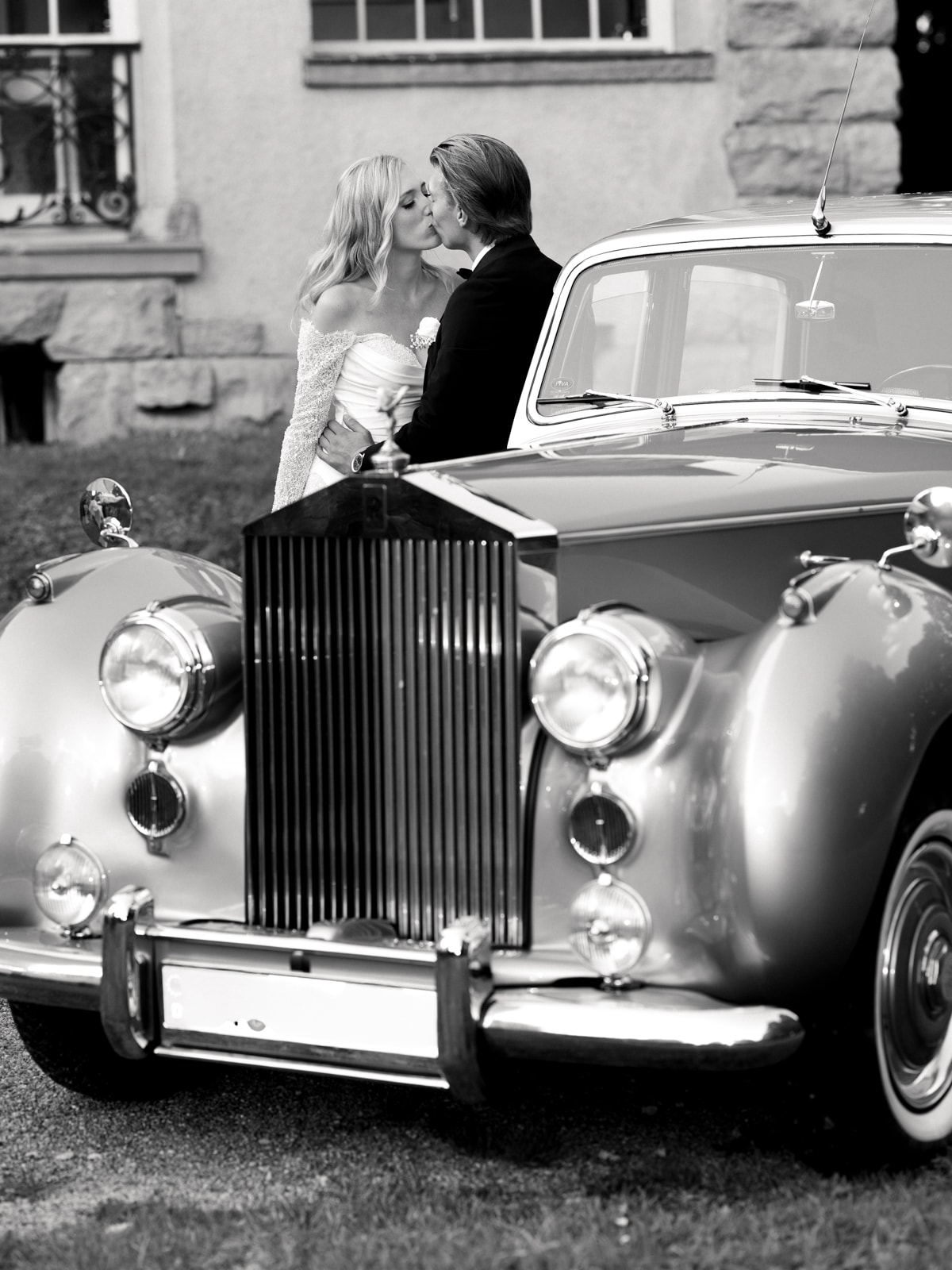 Wedding couple kissing behind Rolls Royce at glamorous Schloss Kartzow castle wedding