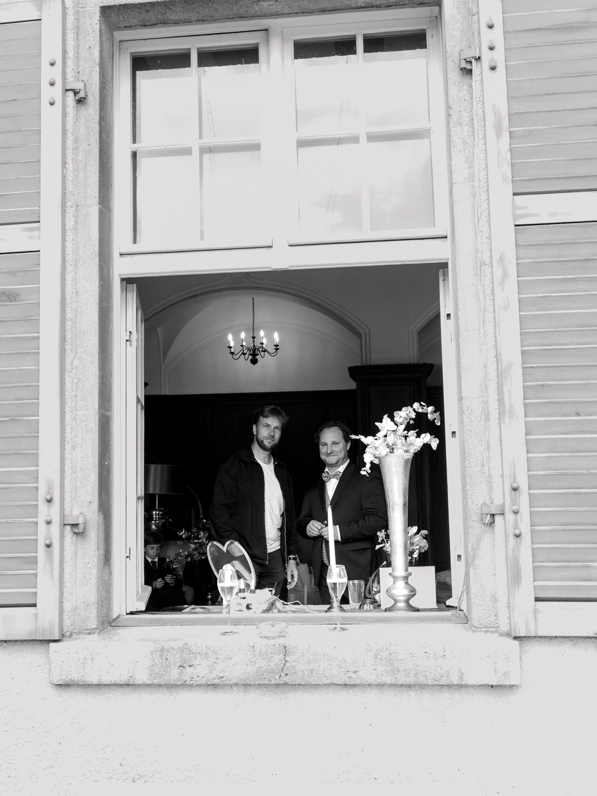 Wedding guests at castle window with champagne glasses during reception at Schloss Kartzow