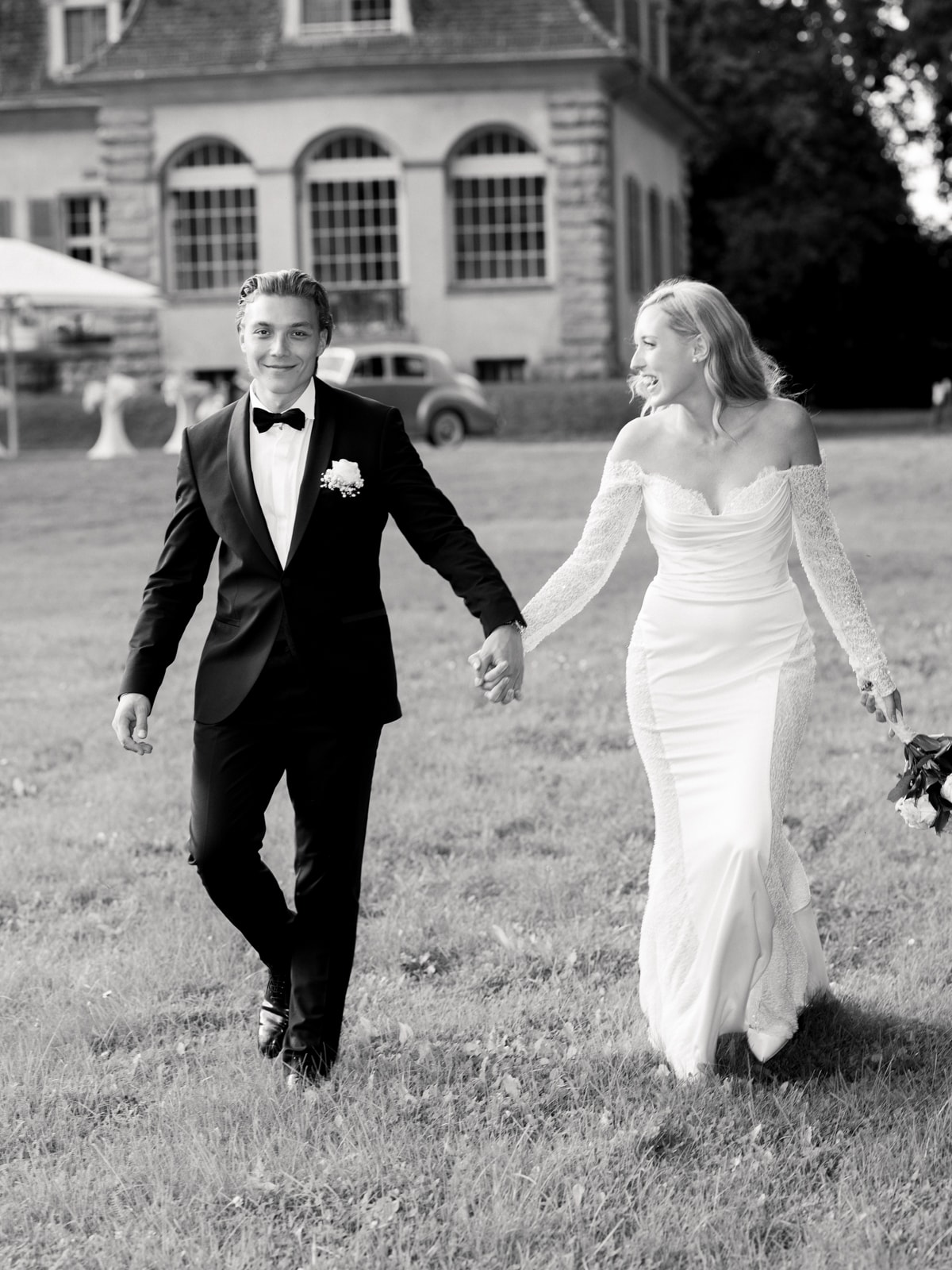 Wedding couple laughing happily in front of Schloss Kartzow at glamorous castle wedding