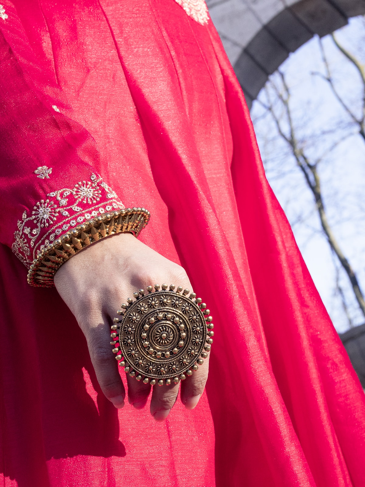Close-up of traditional Indian gold jewelry and embroidered red fabric