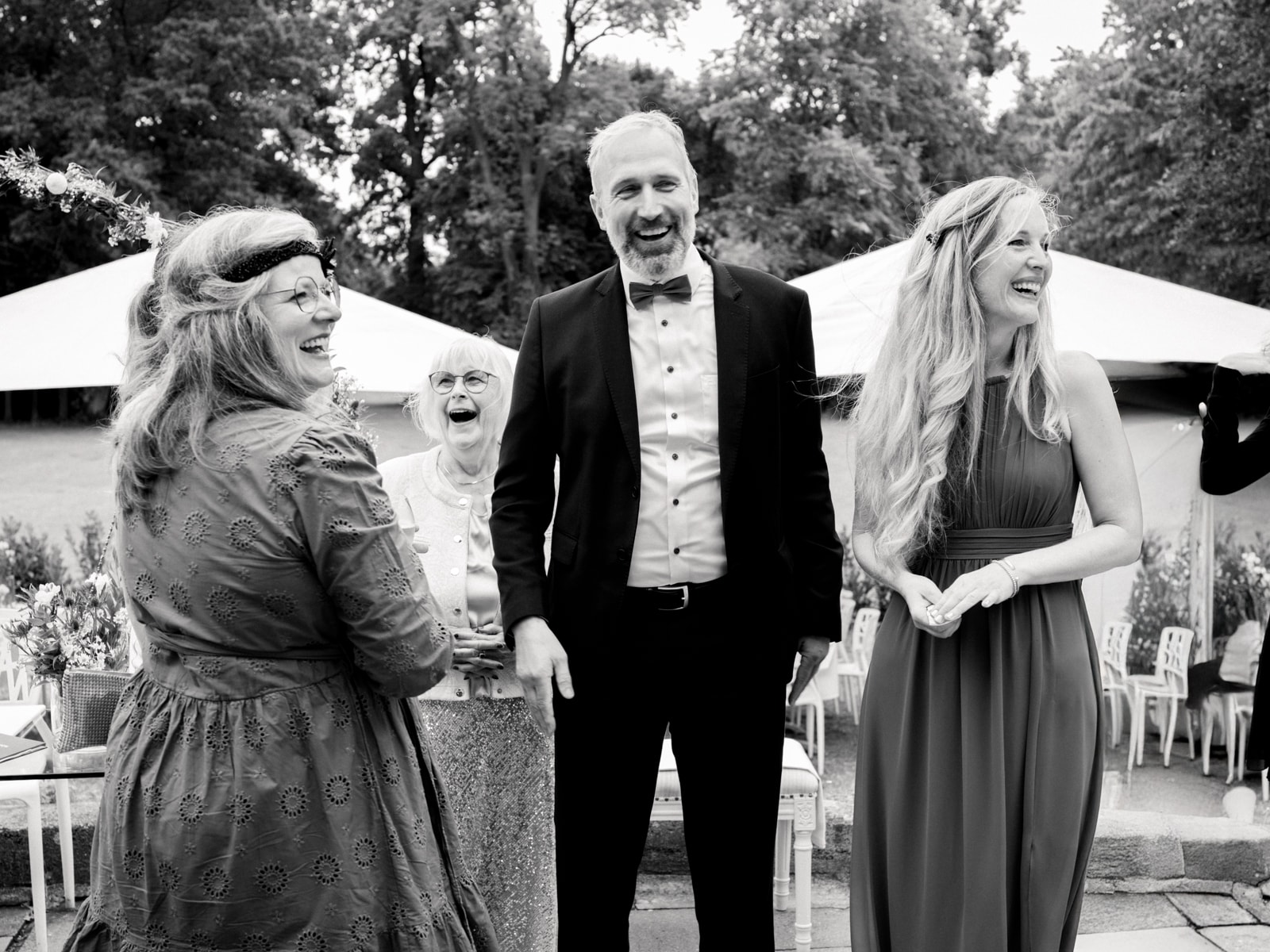 Laughing wedding guests and father of bride at outdoor ceremony Schloss Kartzow