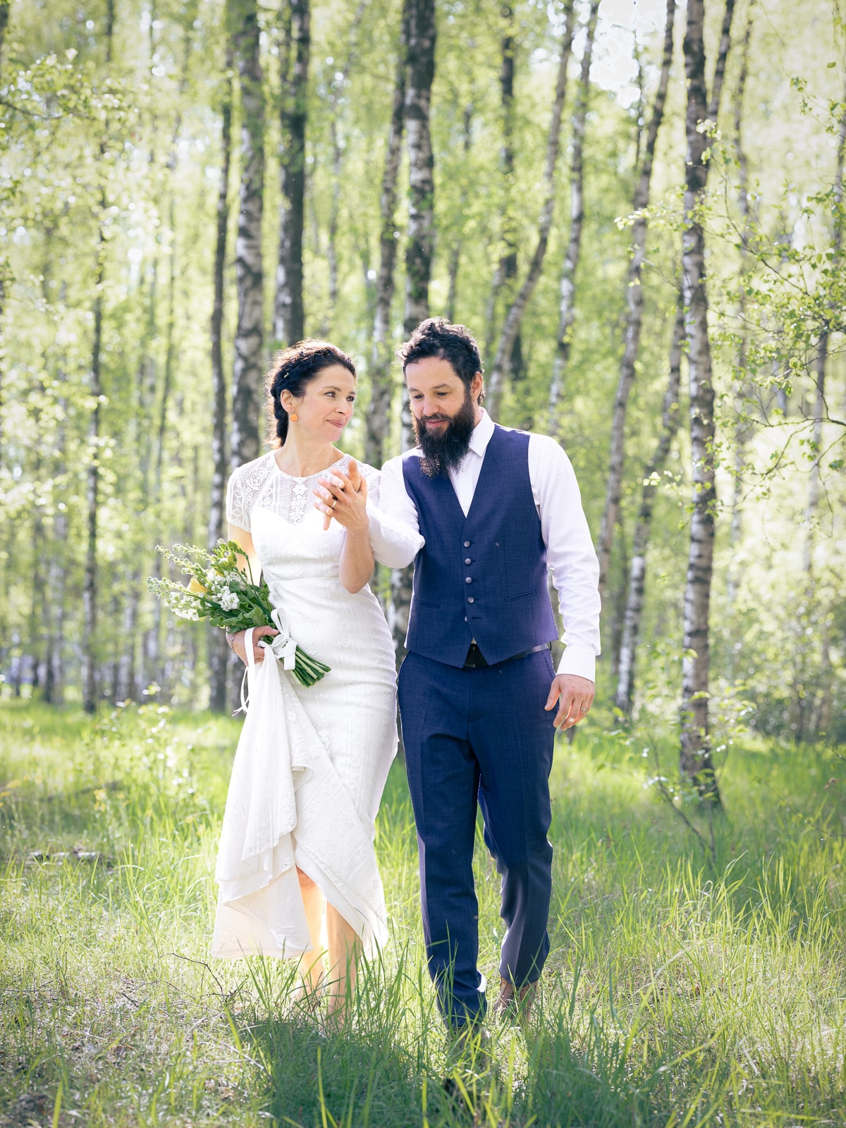 Joyful couple in motion between birch trees